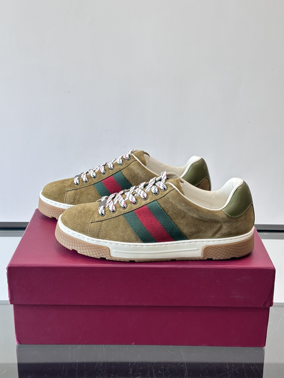 Gucci经典的复古运动鞋，采用麂皮鞋面，搭配品牌标志性的红绿织带，鞋带为红白格纹设计，鞋底为橡胶➕防滑