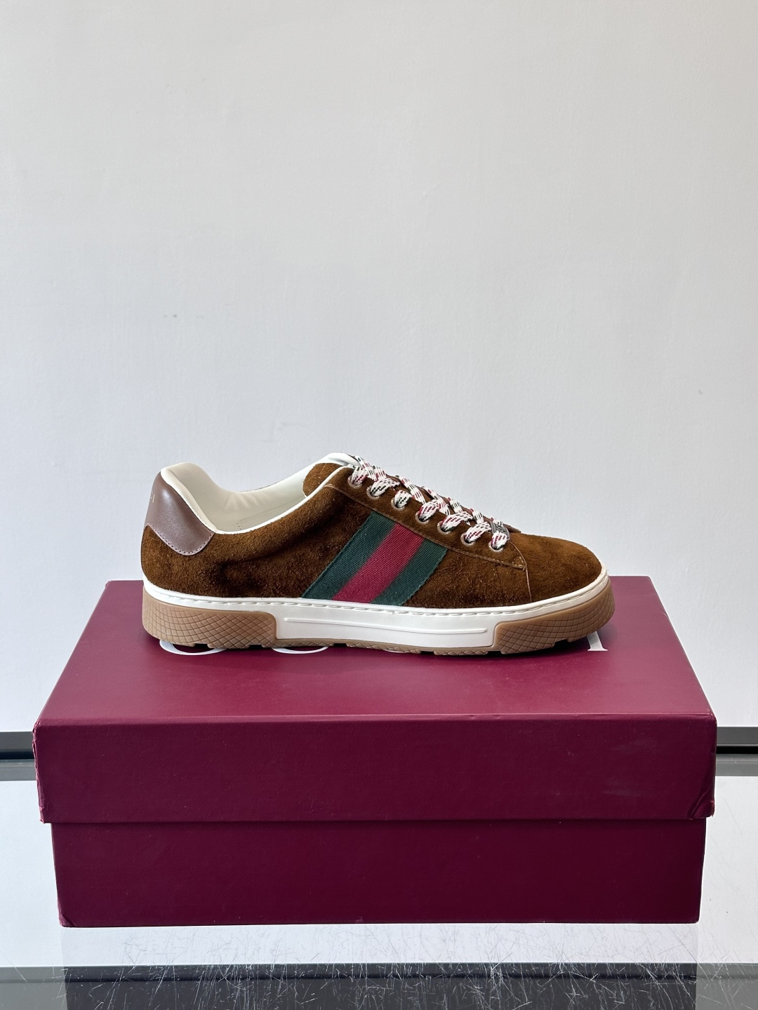 Gucci经典的复古运动鞋，采用麂皮鞋面，搭配品牌标志性的红绿织带，鞋带为红白格纹设计，鞋底为橡胶➕防滑