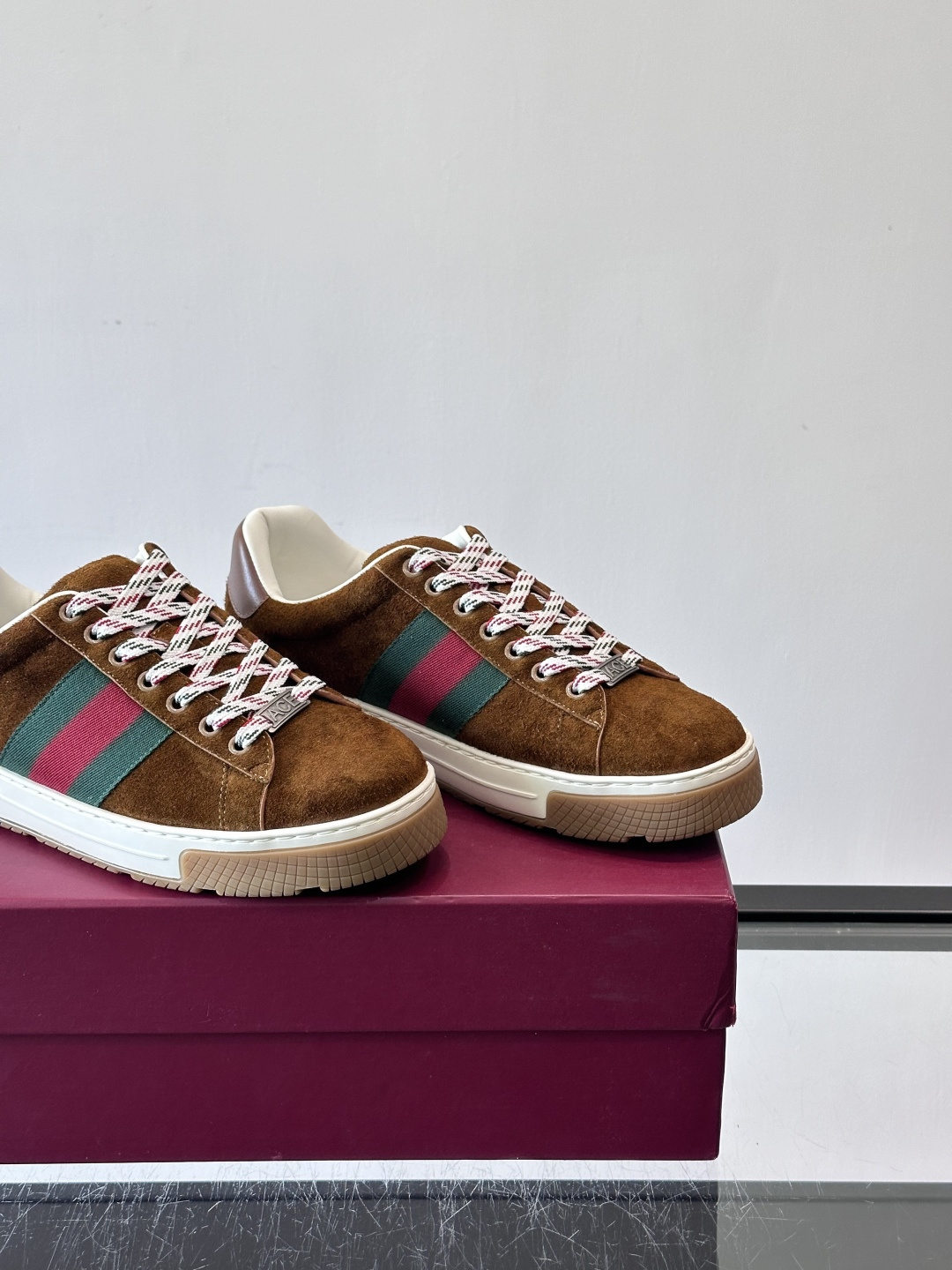 Gucci经典的复古运动鞋，采用麂皮鞋面，搭配品牌标志性的红绿织带，鞋带为红白格纹设计，鞋底为橡胶➕防滑