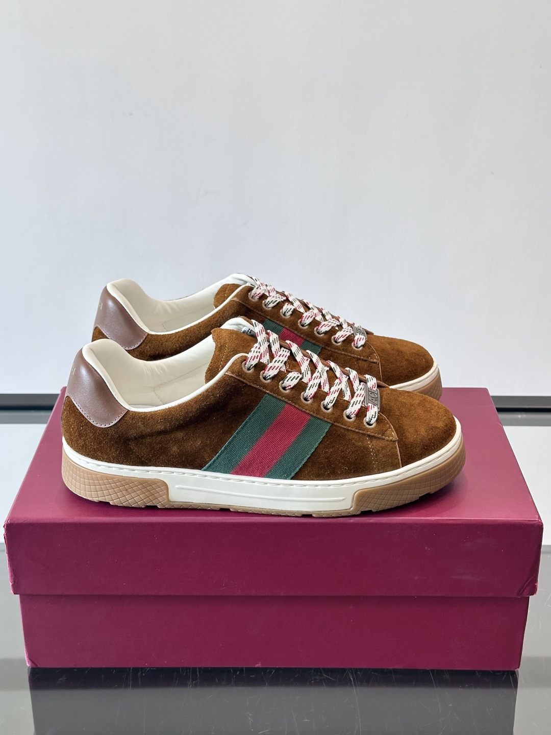 Gucci经典的复古运动鞋，采用麂皮鞋面，搭配品牌标志性的红绿织带，鞋带为红白格纹设计，鞋底为橡胶➕防滑