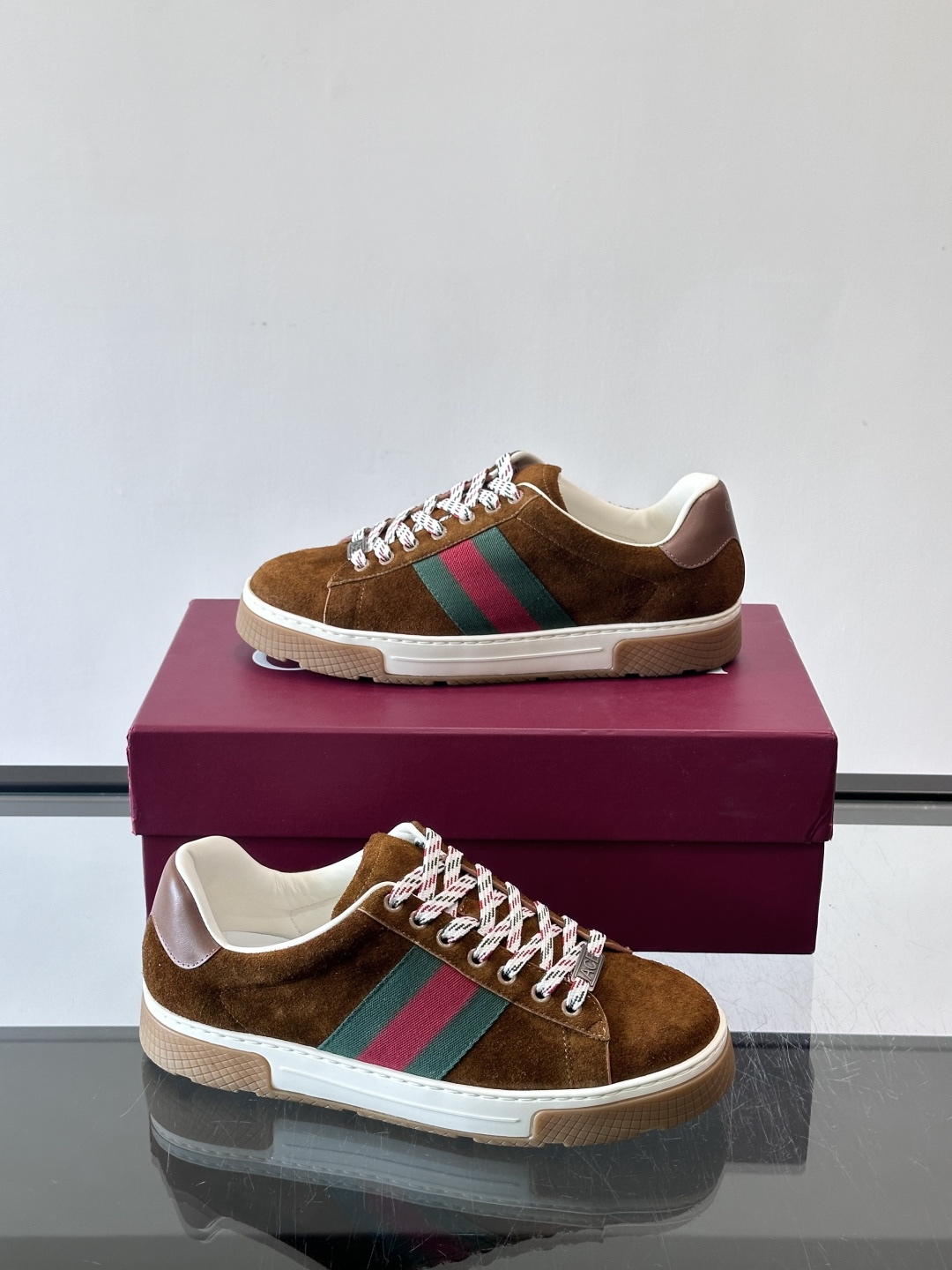 Gucci经典的复古运动鞋，采用麂皮鞋面，搭配品牌标志性的红绿织带，鞋带为红白格纹设计，鞋底为橡胶➕防滑