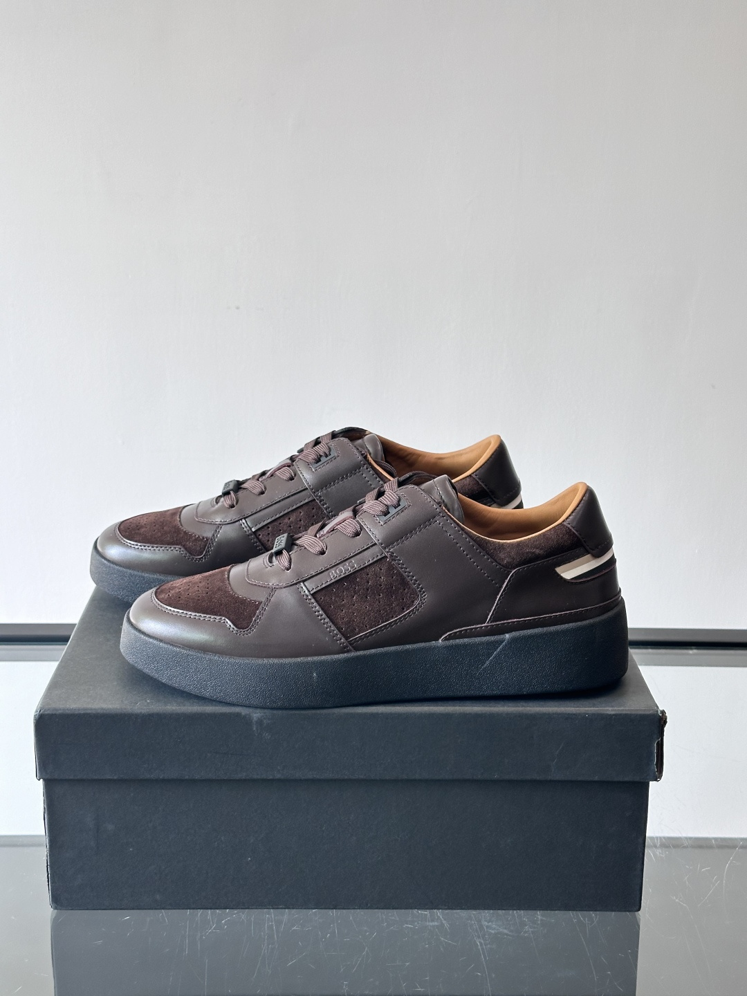 boss男士拼接休闲运动鞋，采用皮革+麂皮材质，质感细腻又耐用。鞋面简约，透气孔设计提升舒适度，橡胶鞋底