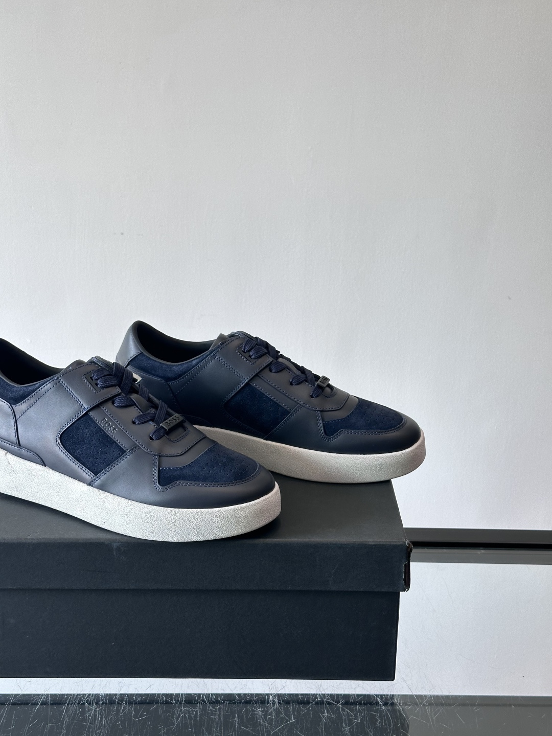 boss男士拼接休闲运动鞋，采用皮革+麂皮材质，质感细腻又耐用。鞋面简约，透气孔设计提升舒适度，橡胶鞋底