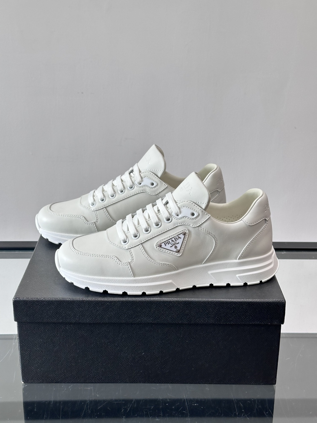 PRADA男士休闲运动鞋，采用优质皮革。舒适又透气！鞋侧三角Logo超有辨识度，简约百搭，日常穿搭无压力