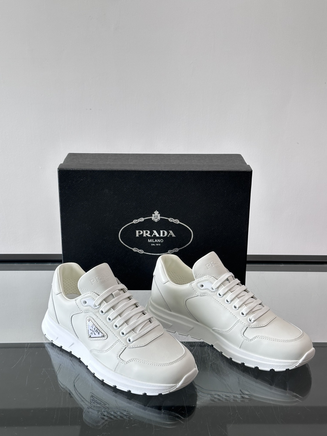 PRADA男士休闲运动鞋，采用优质皮革。舒适又透气！鞋侧三角Logo超有辨识度，简约百搭，日常穿搭无压力