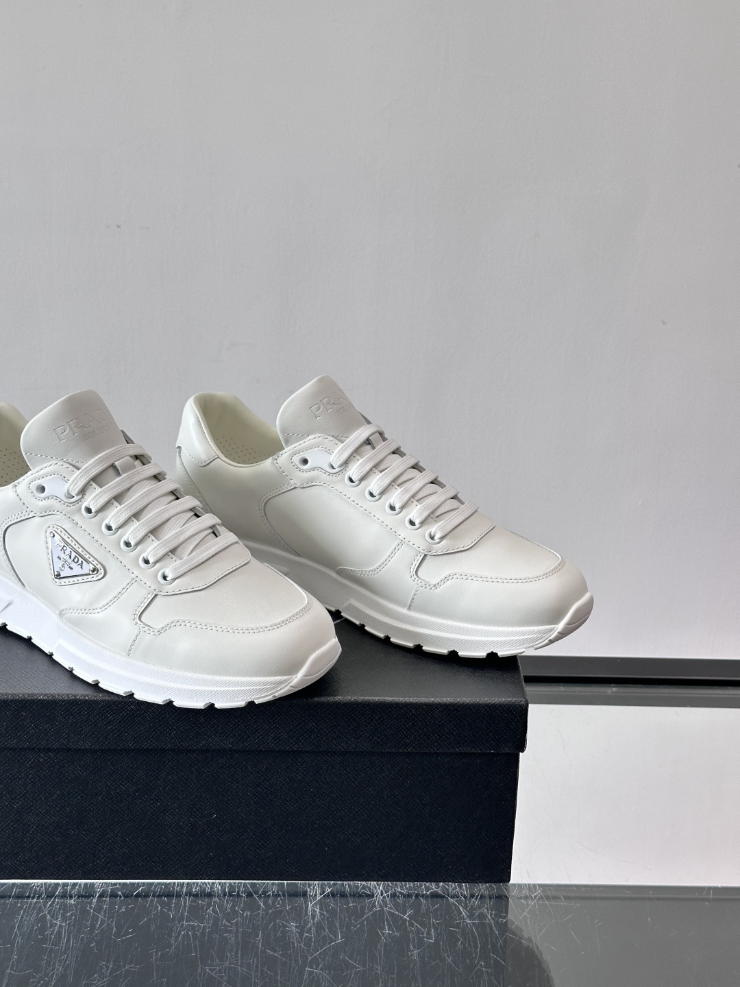 PRADA男士休闲运动鞋，采用优质皮革。舒适又透气！鞋侧三角Logo超有辨识度，简约百搭，日常穿搭无压力