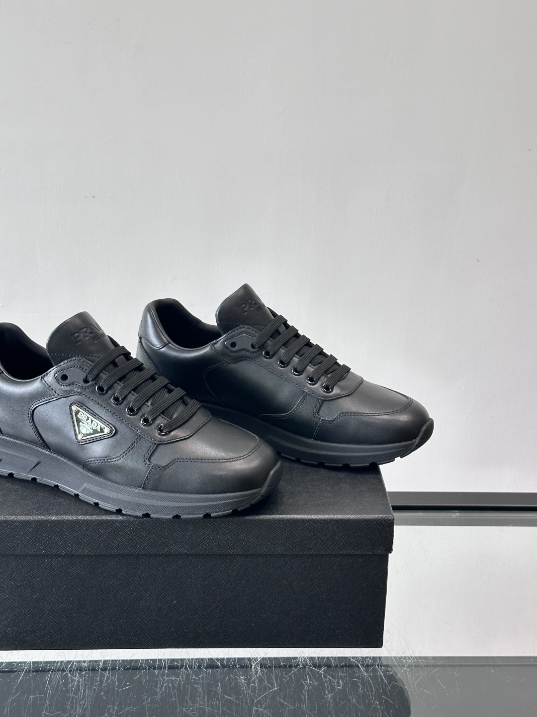 PRADA男士休闲运动鞋，采用优质皮革。舒适又透气！鞋侧三角Logo超有辨识度，简约百搭，日常穿搭无压力