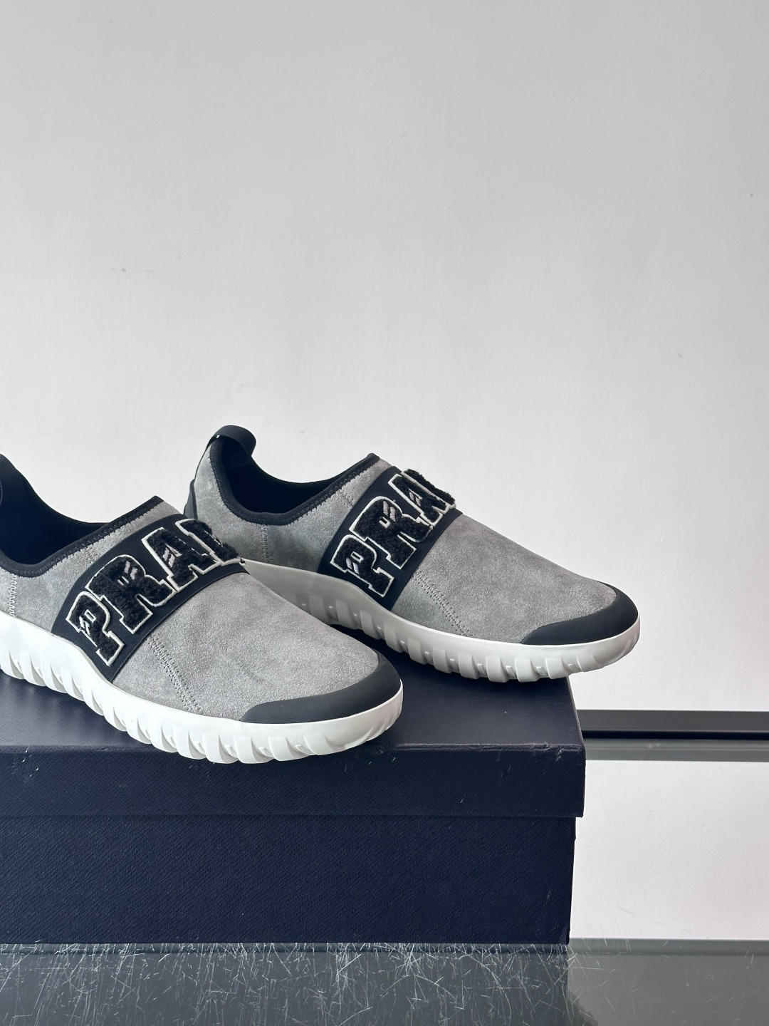 Prada与Ssense联名的Tech-Challenge系列运动鞋，麂皮鞋面+黑色织物条带，白色立体“