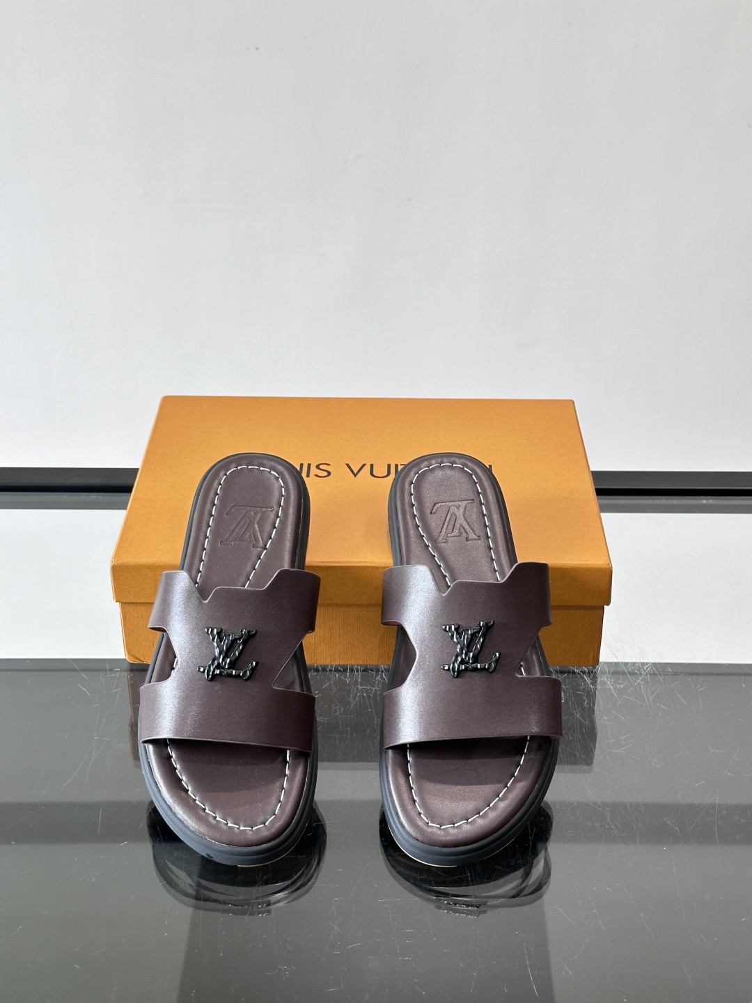 LV Isola凉拖鞋采用牛皮，搭配经典LV金属Logo，简约又有辨识度。鞋底为橡胶材质，白色缝线细节，