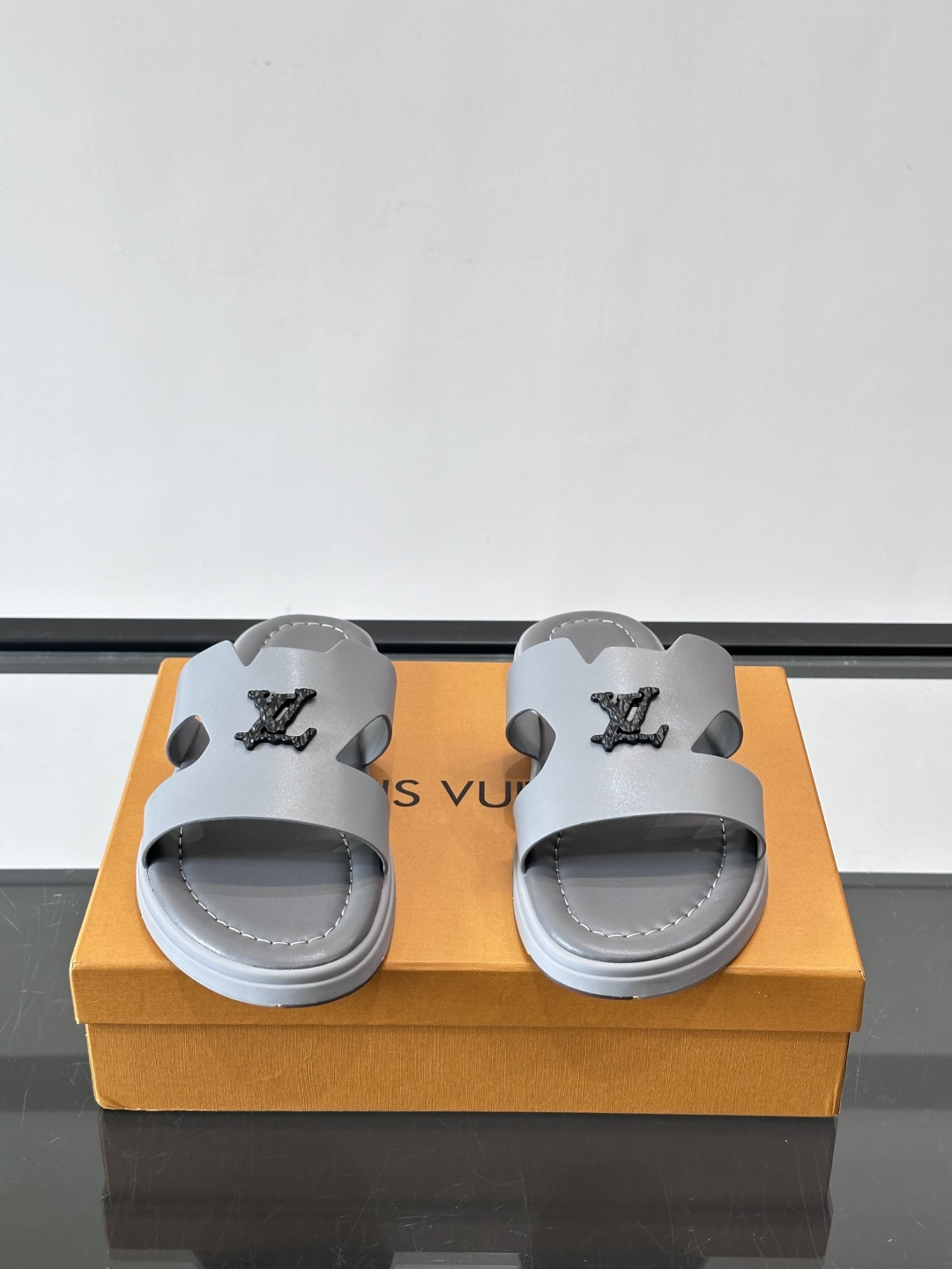 LV Isola凉拖鞋采用牛皮，搭配经典LV金属Logo，简约又有辨识度。鞋底为橡胶材质，白色缝线细节，