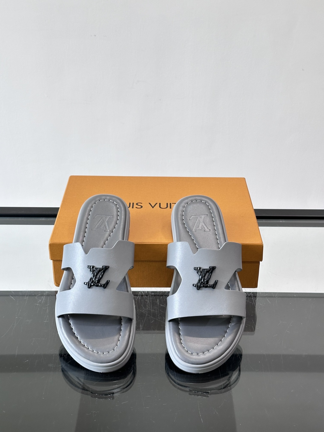 LV Isola凉拖鞋采用牛皮，搭配经典LV金属Logo，简约又有辨识度。鞋底为橡胶材质，白色缝线细节，