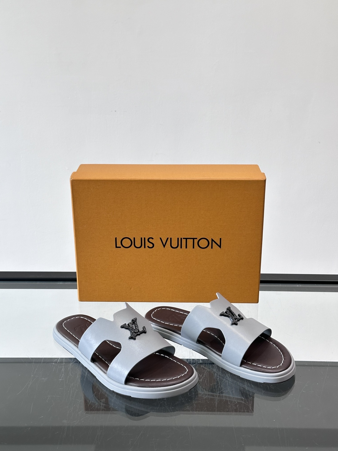 LV Isola凉拖鞋采用牛皮，搭配经典LV金属Logo，简约又有辨识度。鞋底为橡胶材质，白色缝线细节，