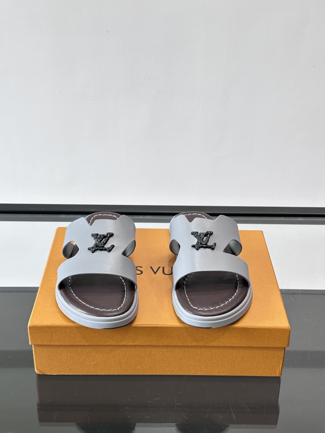LV Isola凉拖鞋采用牛皮，搭配经典LV金属Logo，简约又有辨识度。鞋底为橡胶材质，白色缝线细节，