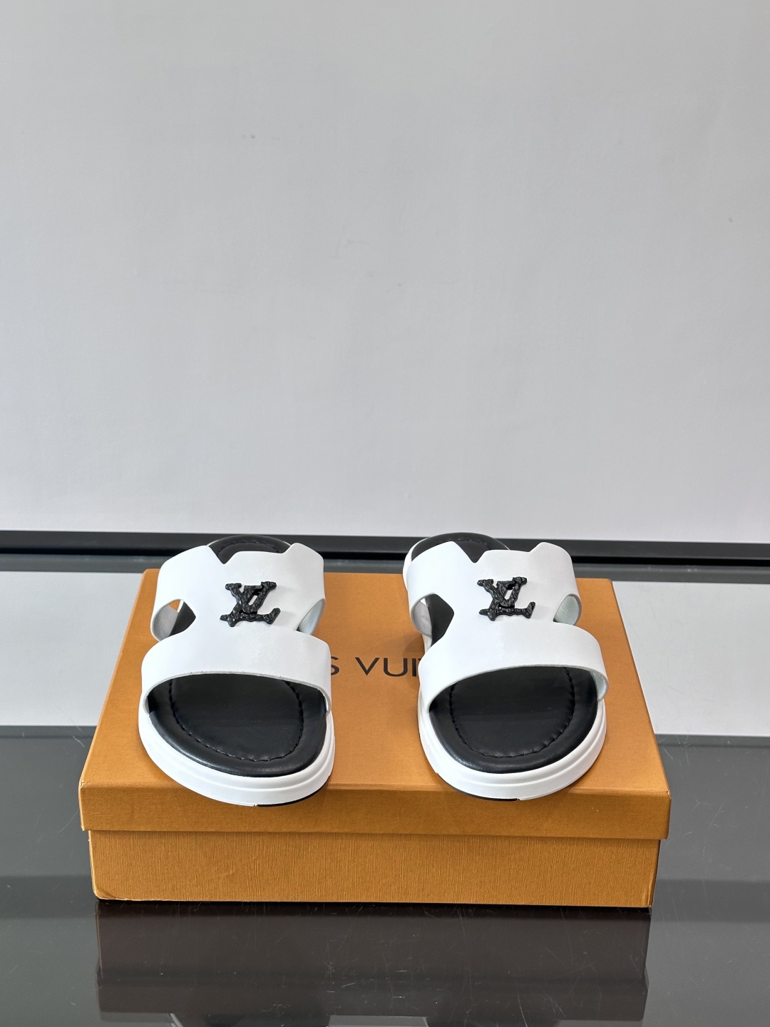 LV Isola凉拖鞋采用牛皮，搭配经典LV金属Logo，简约又有辨识度。鞋底为橡胶材质，白色缝线细节，
