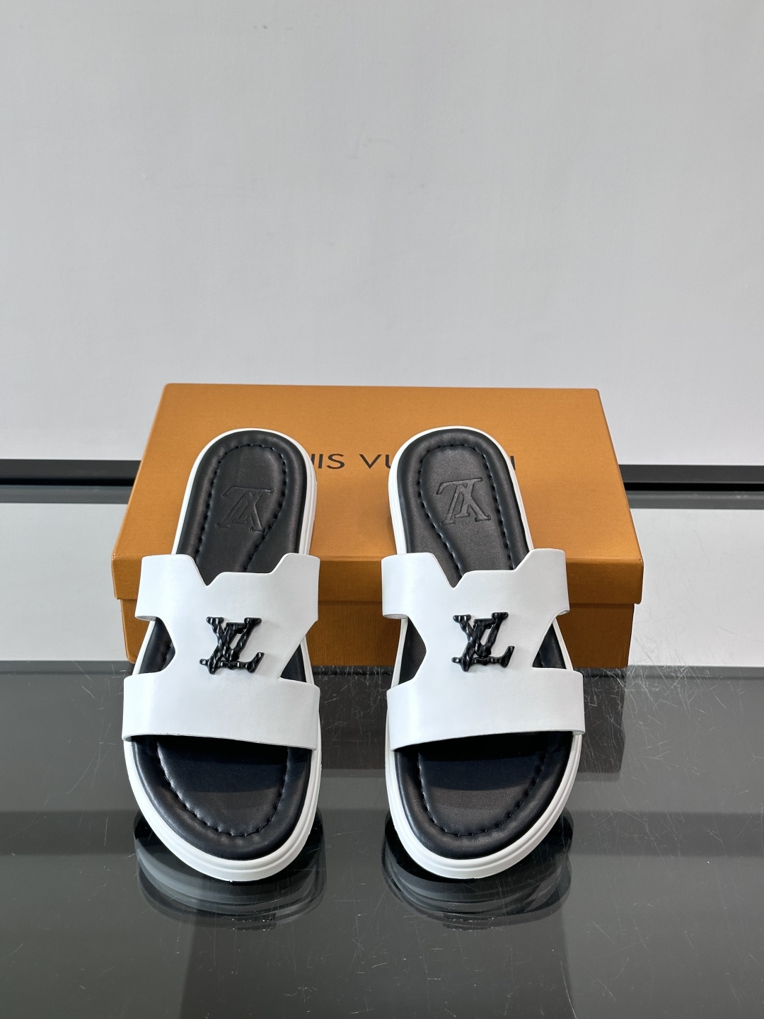 LV Isola凉拖鞋采用牛皮，搭配经典LV金属Logo，简约又有辨识度。鞋底为橡胶材质，白色缝线细节，
