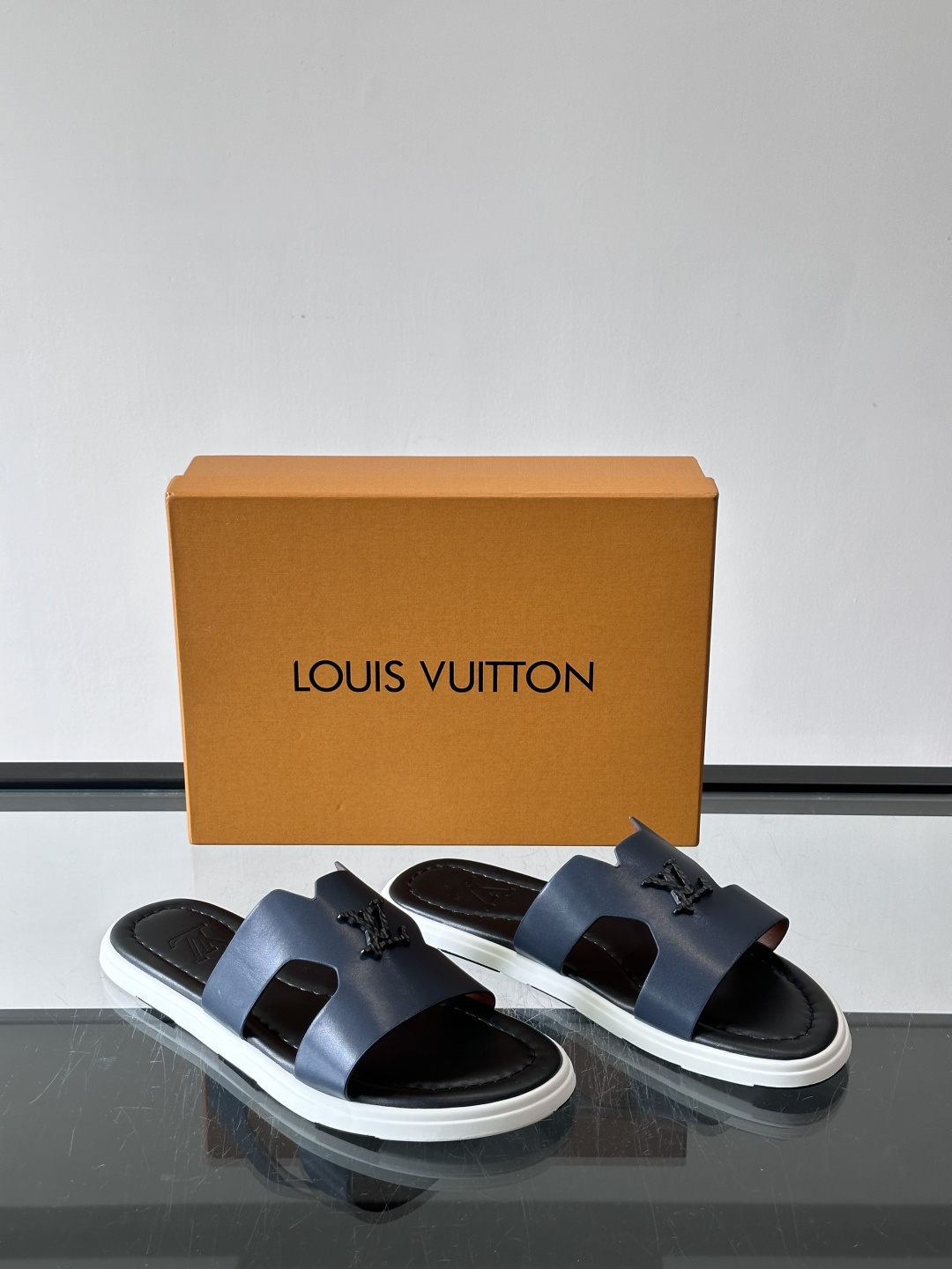 LV Isola凉拖鞋采用牛皮，搭配经典LV金属Logo，简约又有辨识度。鞋底为橡胶材质，白色缝线细节，