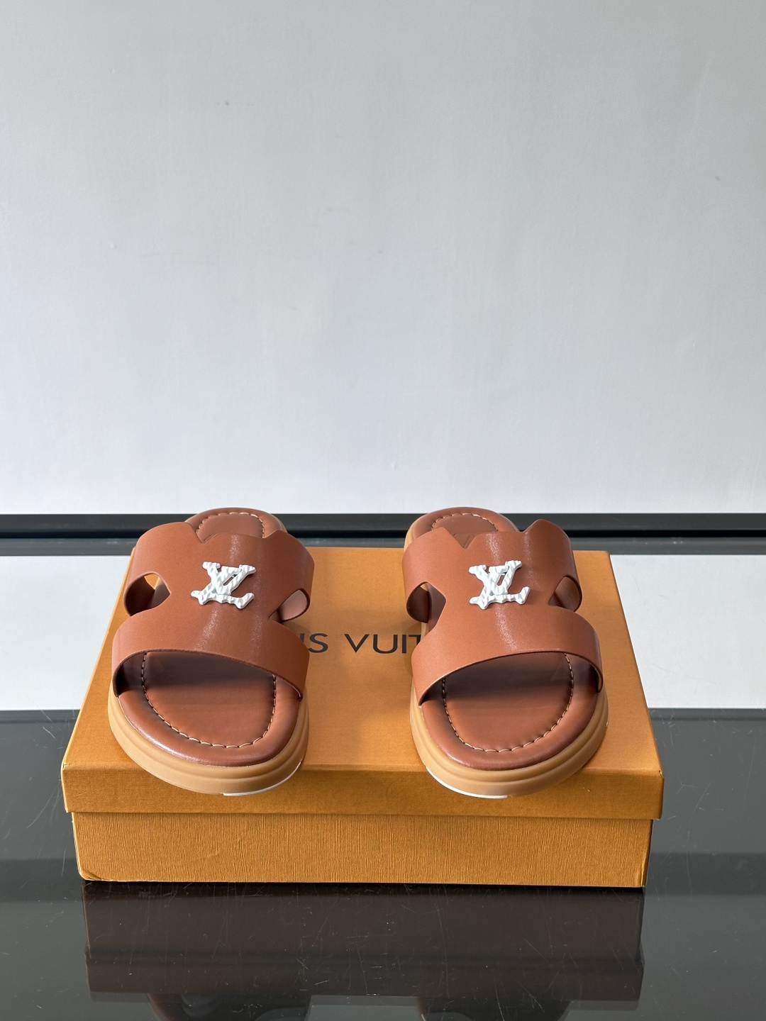 LV Isola凉拖鞋采用牛皮，搭配经典LV金属Logo，简约又有辨识度。鞋底为橡胶材质，白色缝线细节，