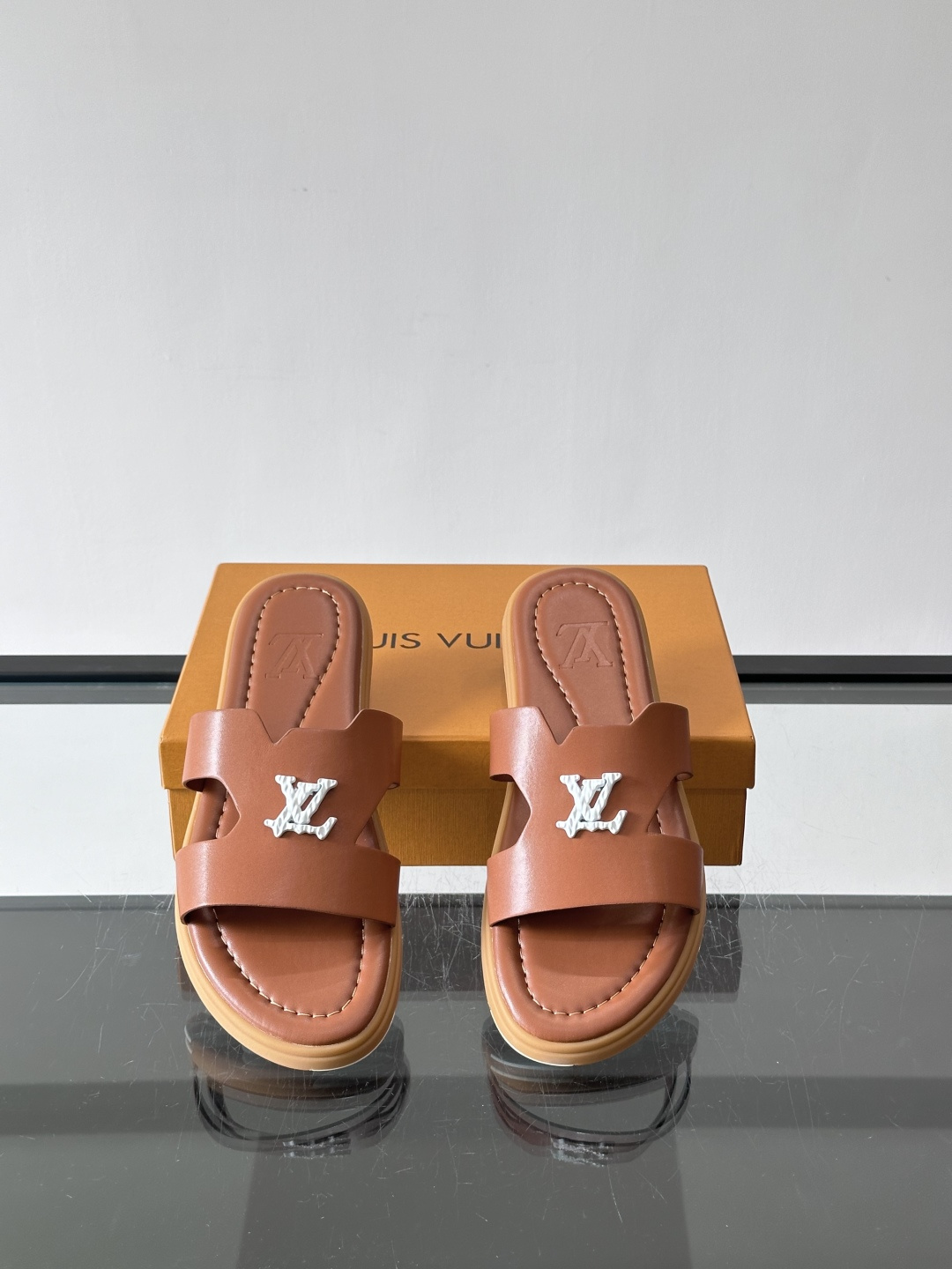 LV Isola凉拖鞋采用牛皮，搭配经典LV金属Logo，简约又有辨识度。鞋底为橡胶材质，白色缝线细节，