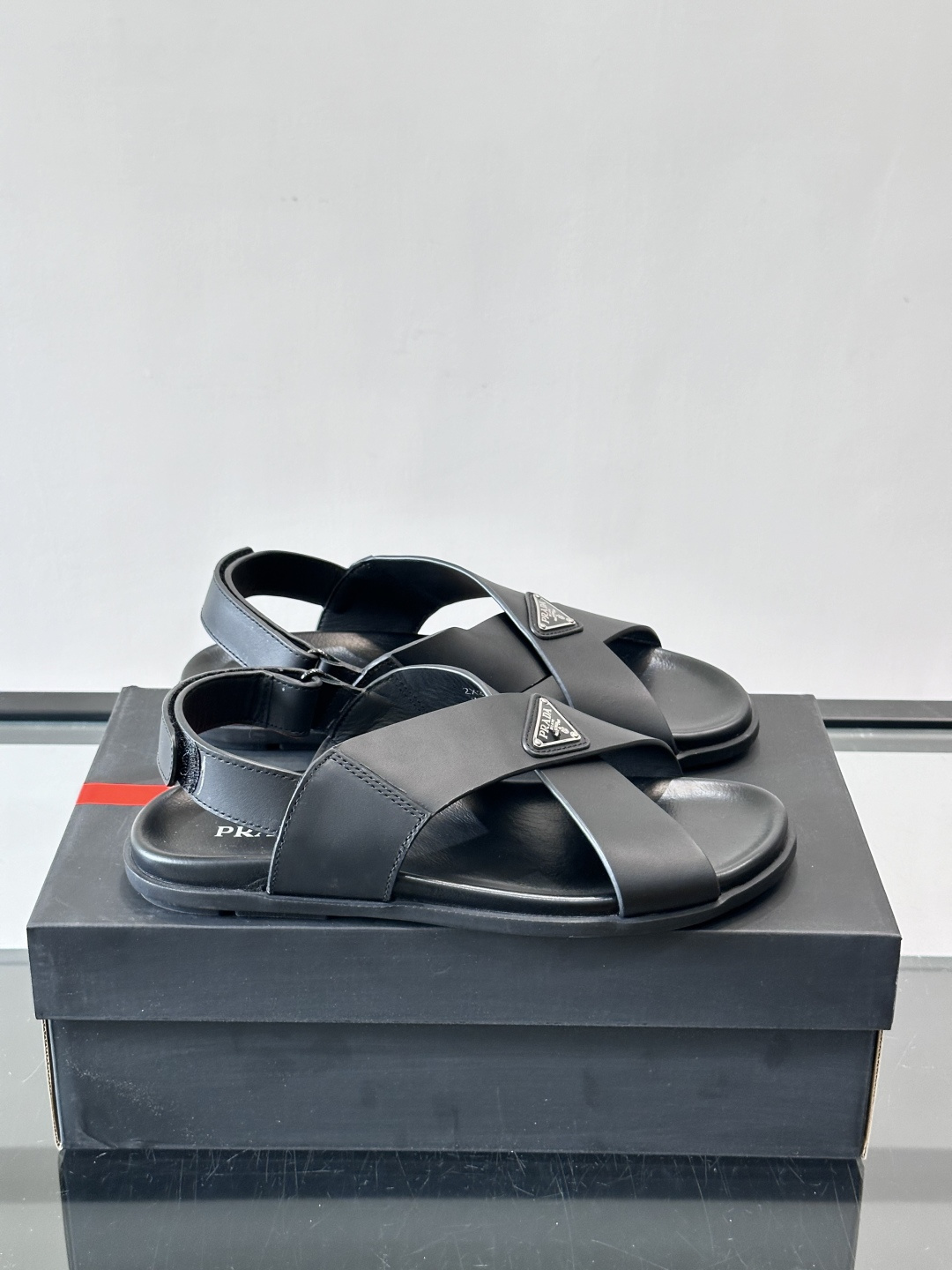NO:851374,Prada's black cross-strap sandals are made of high-quality leather and matched with the classic triangle metal logo. They are simple and recognizable. The flat-bottom design is super comfortable for daily wear, and the heel is adjustable and suitable for various foot types. Whether paired with jeans or casual pants, they can easily enhance your fashion sense and are a must-have item for summer!  ,size39-44 (45.46 customized),,prada,sandals,jeans19860909Prada这款黑色交叉带凉鞋,采用优质皮革,搭配经典三角金属Logo,简约又有辨识度.平底设计,日常穿着超舒适,后跟可调节,适合各种脚型.无论搭配牛仔裤还是休闲裤,都能轻松提升时尚感,是夏季百搭必备单品！ ,size39-44（45.46定制）,,prada,sandals,jeans,Men's shoes