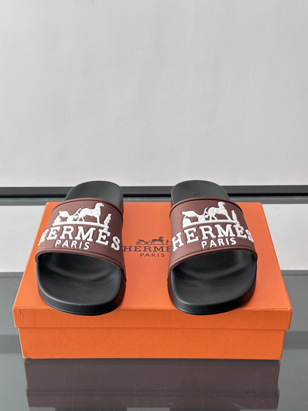 Hermès男士拖鞋，采用柔软橡胶材质，鞋面印有经典马车图案和“HERMÈS PARIS”字样，品牌感满