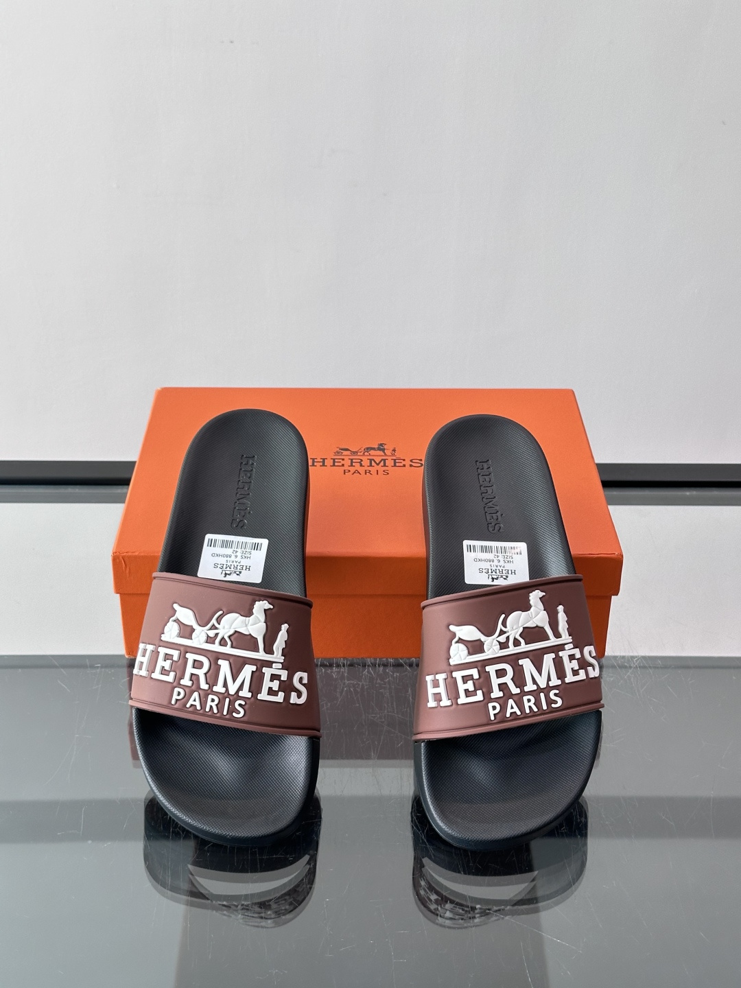 Hermès男士拖鞋，采用柔软橡胶材质，鞋面印有经典马车图案和“HERMÈS PARIS”字样，品牌感满