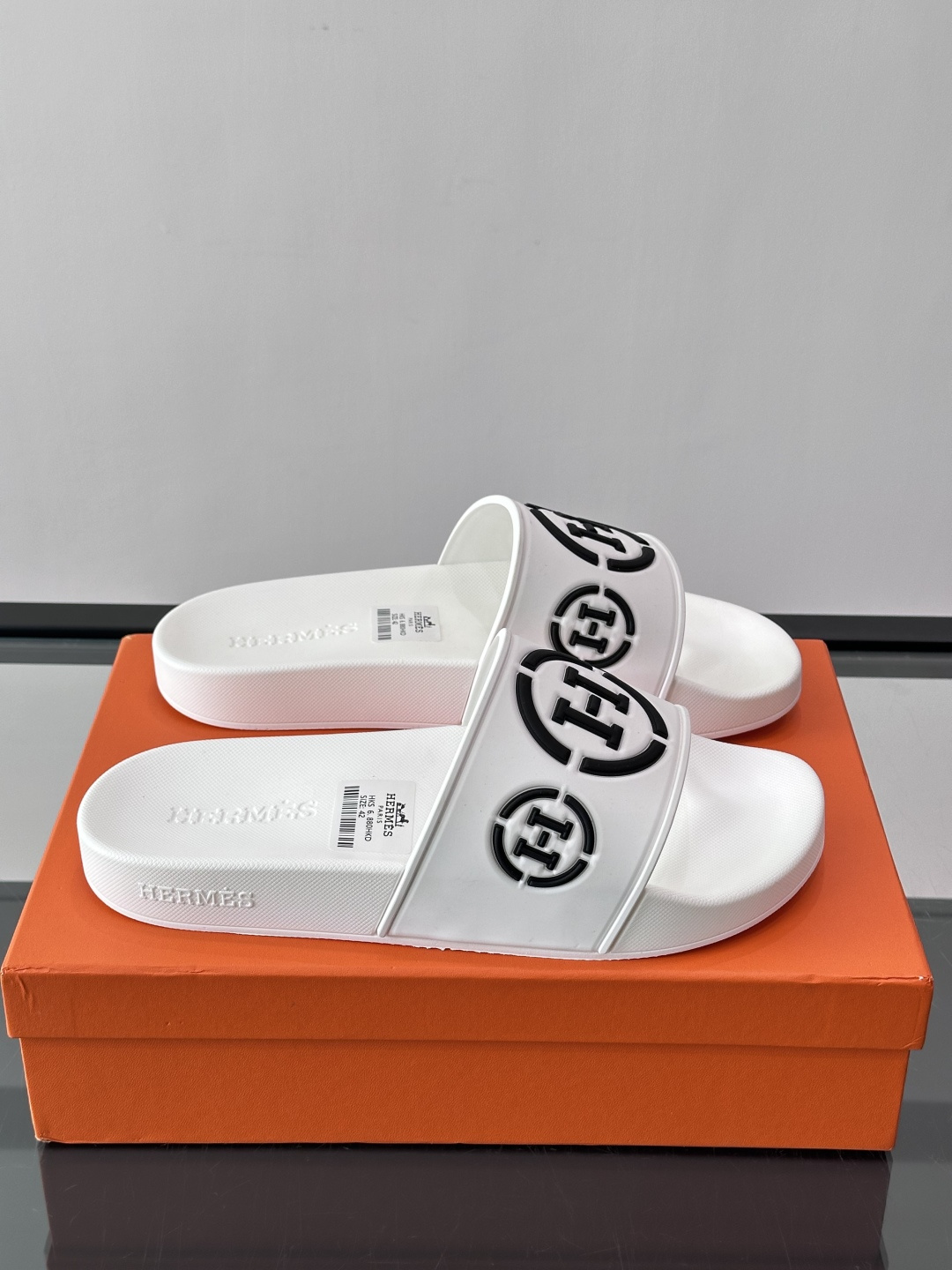 Hermès男士拖鞋，采用柔软橡胶材质，鞋面印有经典马车图案和“HERMÈS PARIS”字样，品牌感满
