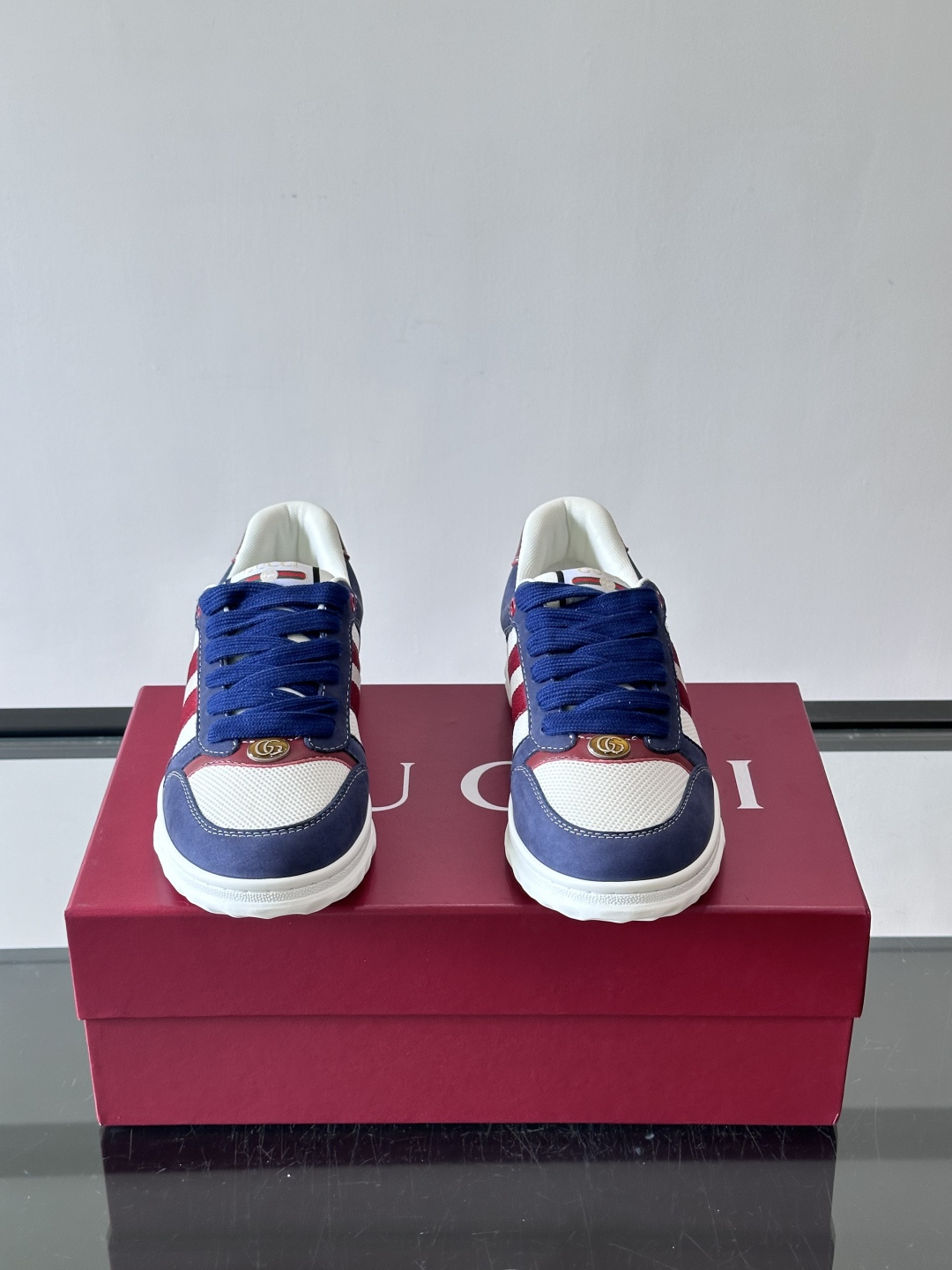 这双也是 ​​Gucci RE-WEB 运动鞋​​，白色皮革鞋身搭配红色织带条纹，金色 GG 金属扣，鞋