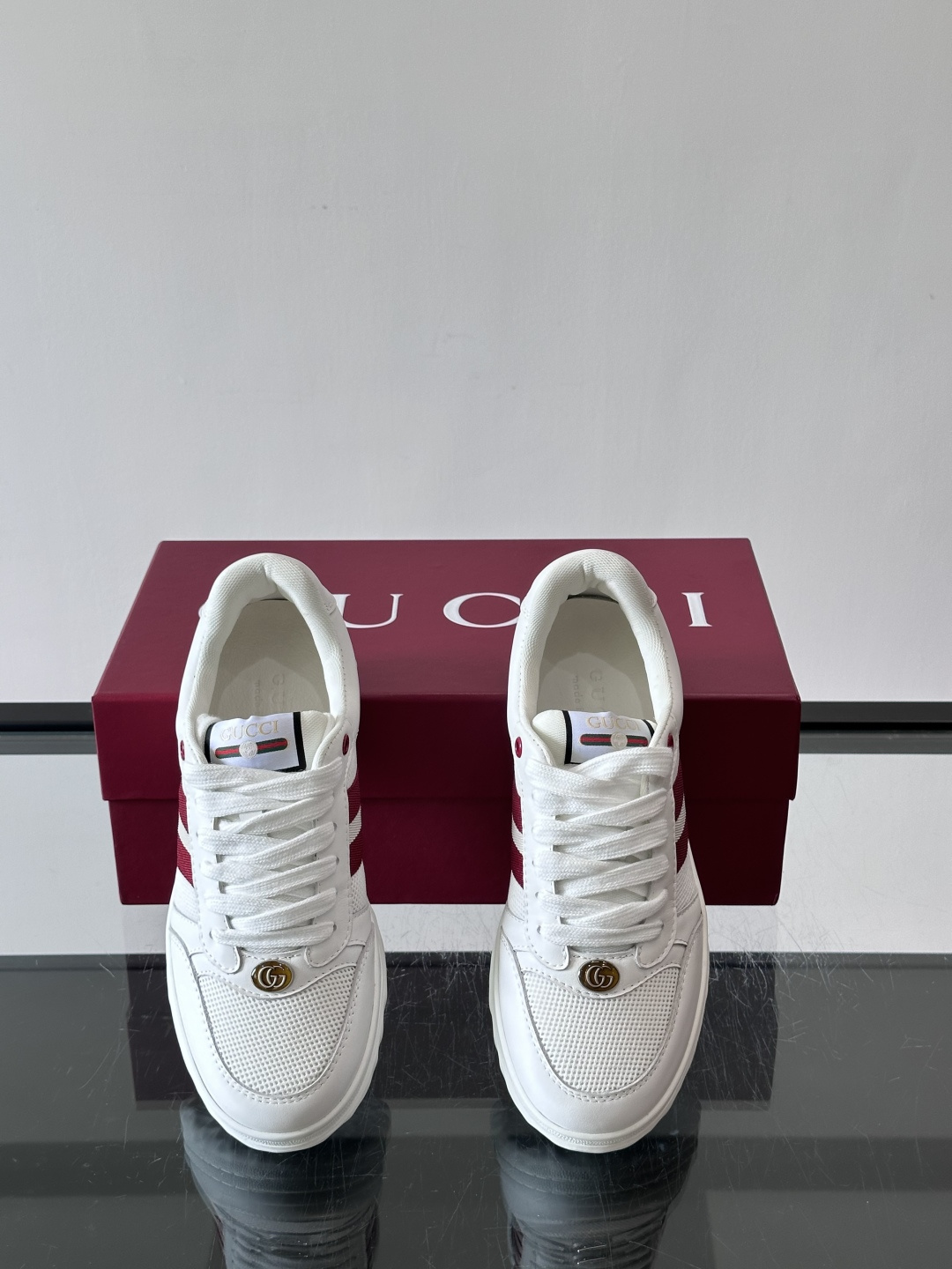 这双也是 ​​Gucci RE-WEB 运动鞋​​，白色皮革鞋身搭配红色织带条纹，金色 GG 金属扣，鞋