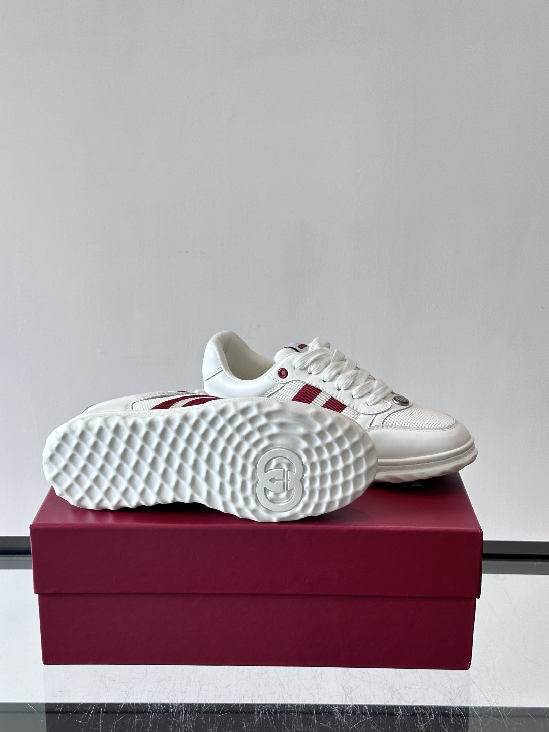 这双也是 ​​Gucci RE-WEB 运动鞋​​，白色皮革鞋身搭配红色织带条纹，金色 GG 金属扣，鞋