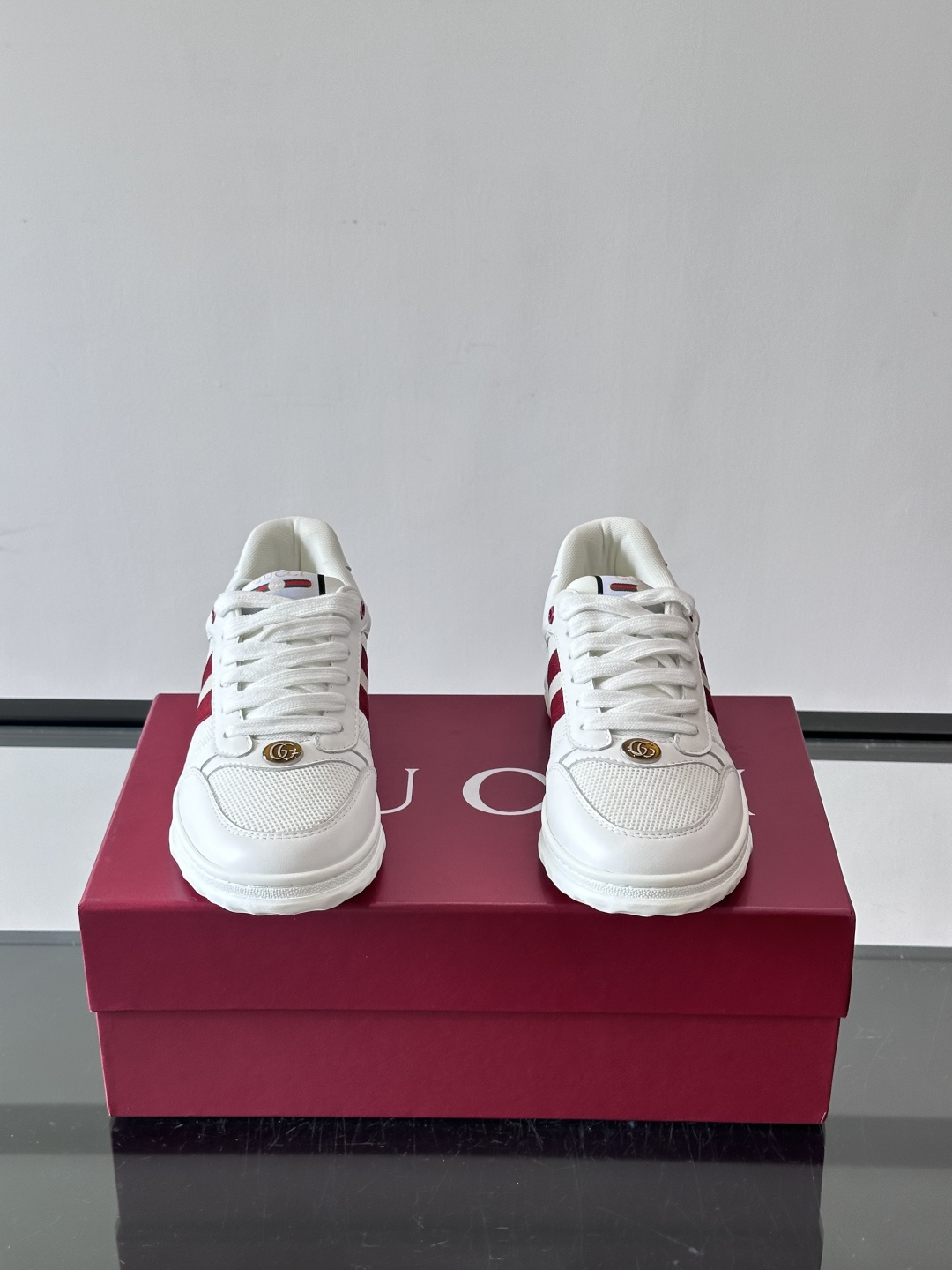 这双也是 ​​Gucci RE-WEB 运动鞋​​，白色皮革鞋身搭配红色织带条纹，金色 GG 金属扣，鞋