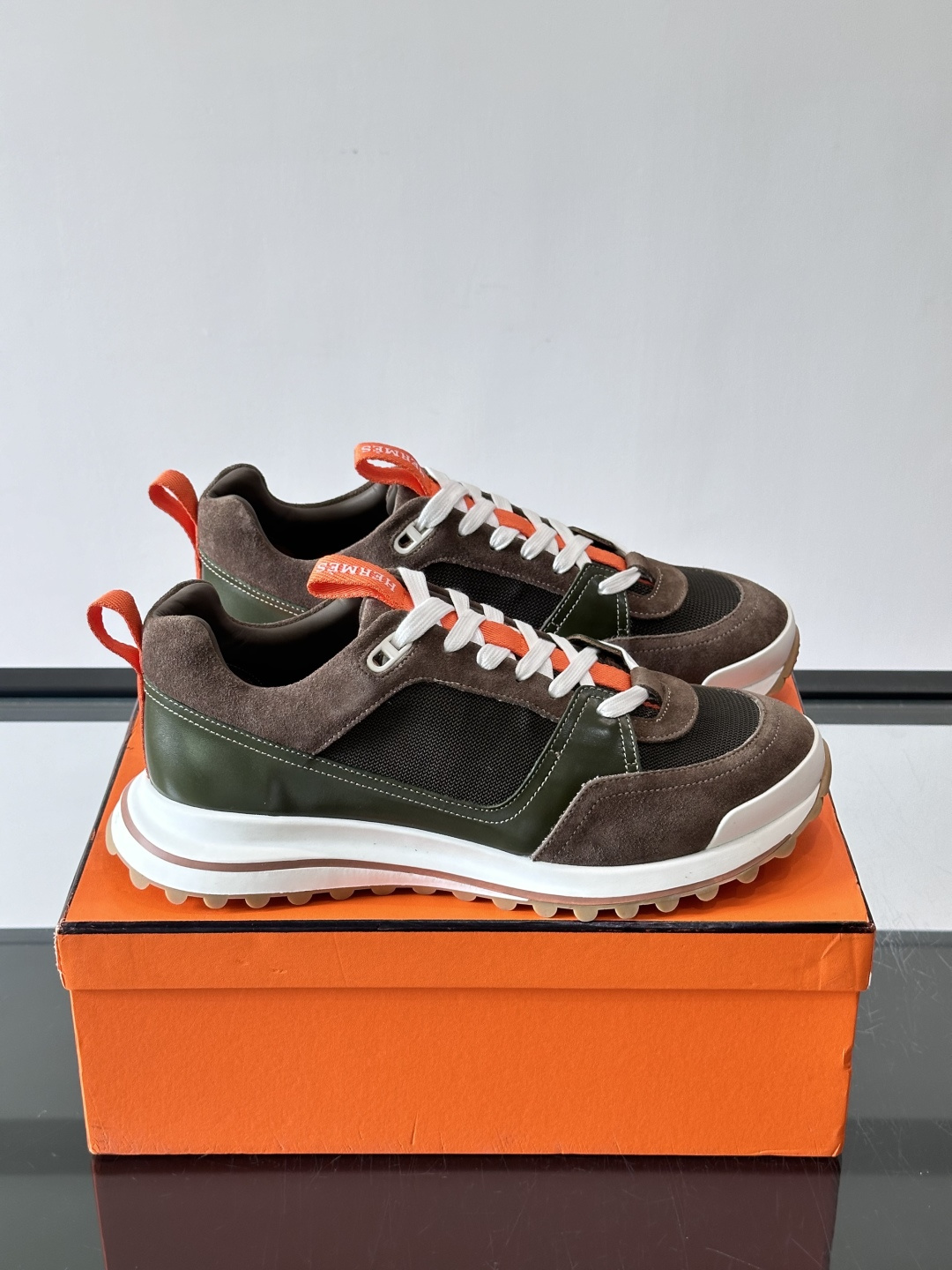 ​​Hermès（爱马仕）的 H08 运动鞋​​，军绿色/墨绿色调，翻毛皮拼接网面，橙色鞋带是很经典的 