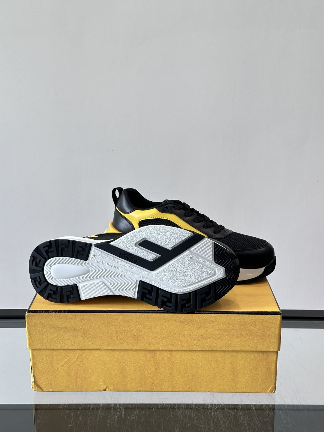​​Fendi Flow 运动鞋​​，白色为主色调，网面拼接皮革，黑色 FENDI 品牌条带贯穿侧面，厚