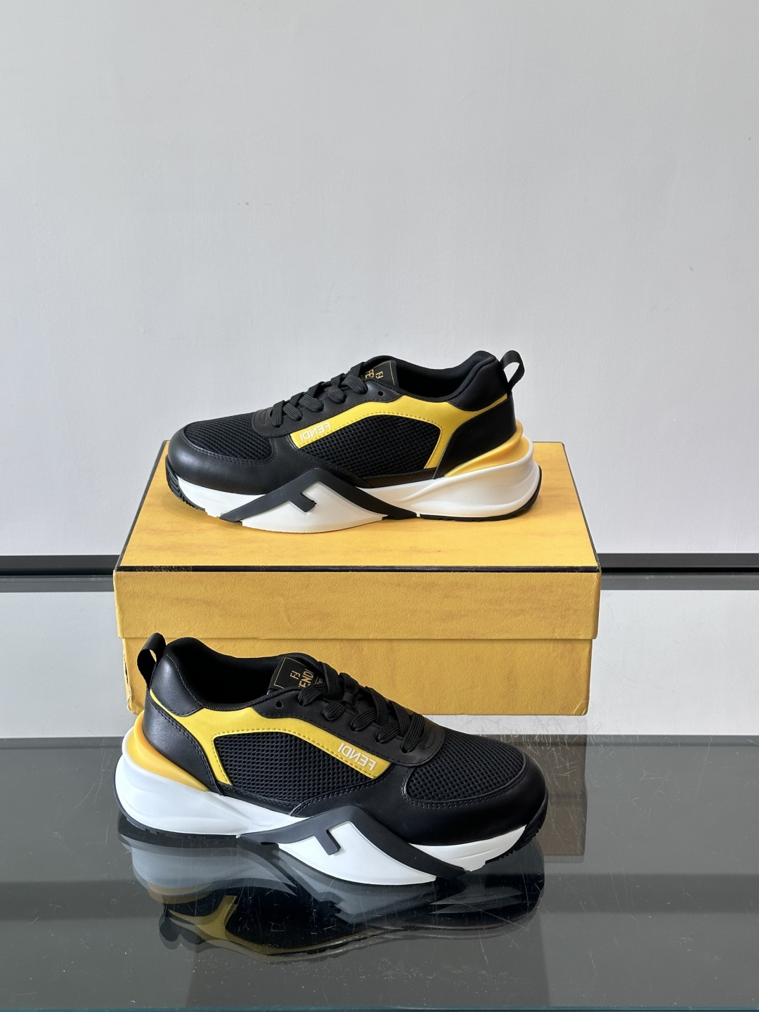 ​​Fendi Flow 运动鞋​​，白色为主色调，网面拼接皮革，黑色 FENDI 品牌条带贯穿侧面，厚