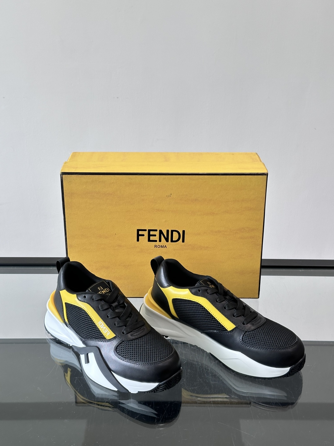 ​​Fendi Flow 运动鞋​​，白色为主色调，网面拼接皮革，黑色 FENDI 品牌条带贯穿侧面，厚