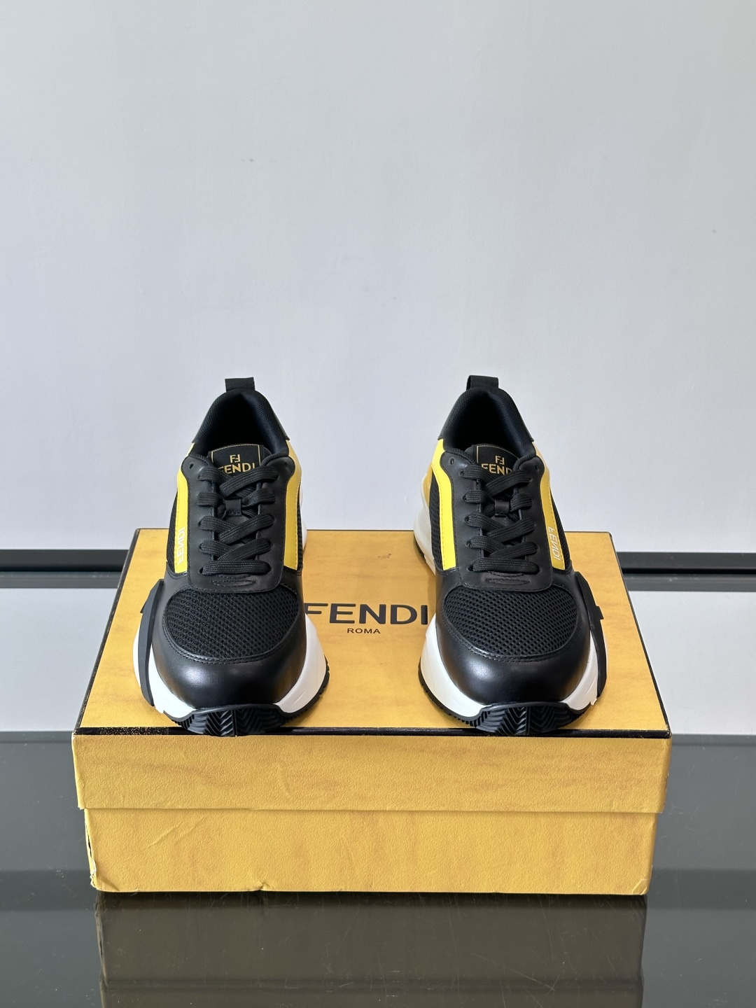 ​​Fendi Flow 运动鞋​​，白色为主色调，网面拼接皮革，黑色 FENDI 品牌条带贯穿侧面，厚