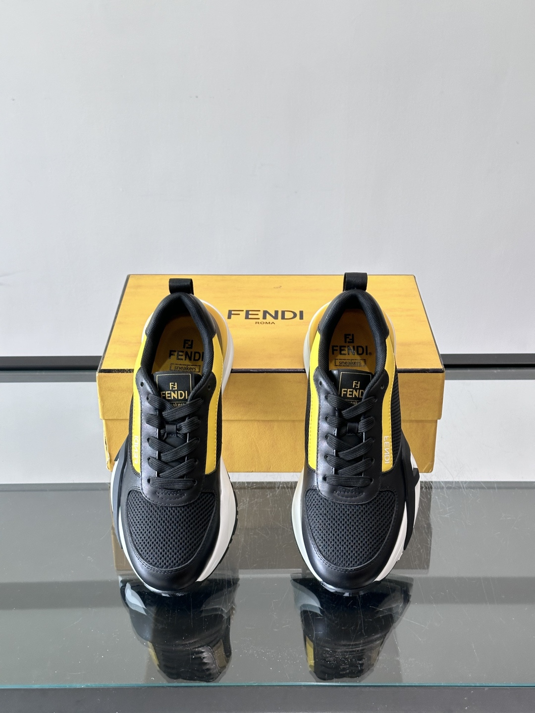 ​​Fendi Flow 运动鞋​​，白色为主色调，网面拼接皮革，黑色 FENDI 品牌条带贯穿侧面，厚