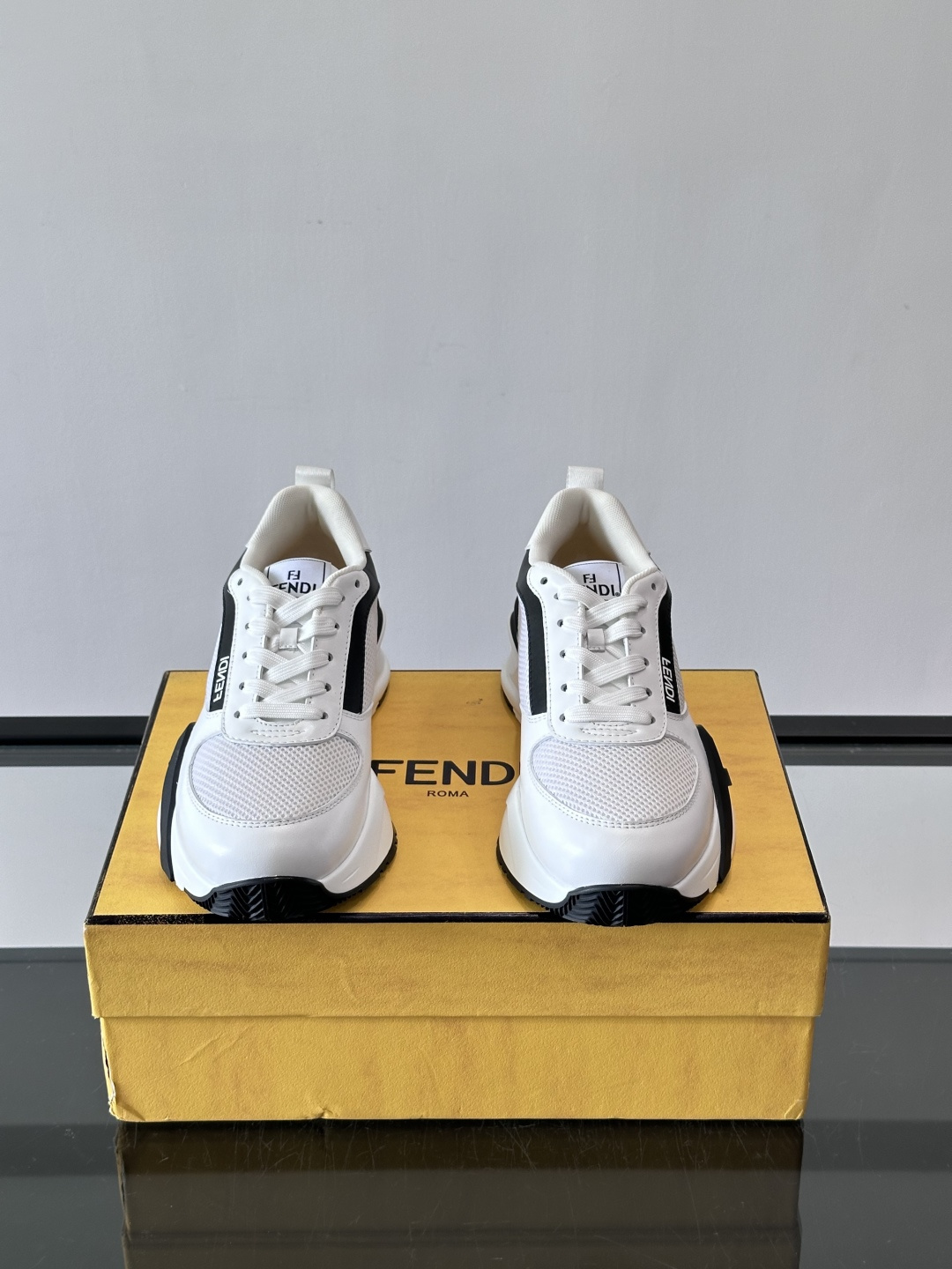 ​​Fendi Flow 运动鞋​​，白色为主色调，网面拼接皮革，黑色 FENDI 品牌条带贯穿侧面，厚