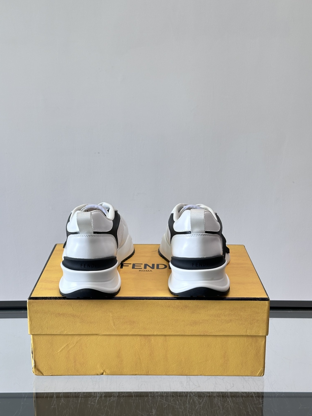 ​​Fendi Flow 运动鞋​​，白色为主色调，网面拼接皮革，黑色 FENDI 品牌条带贯穿侧面，厚