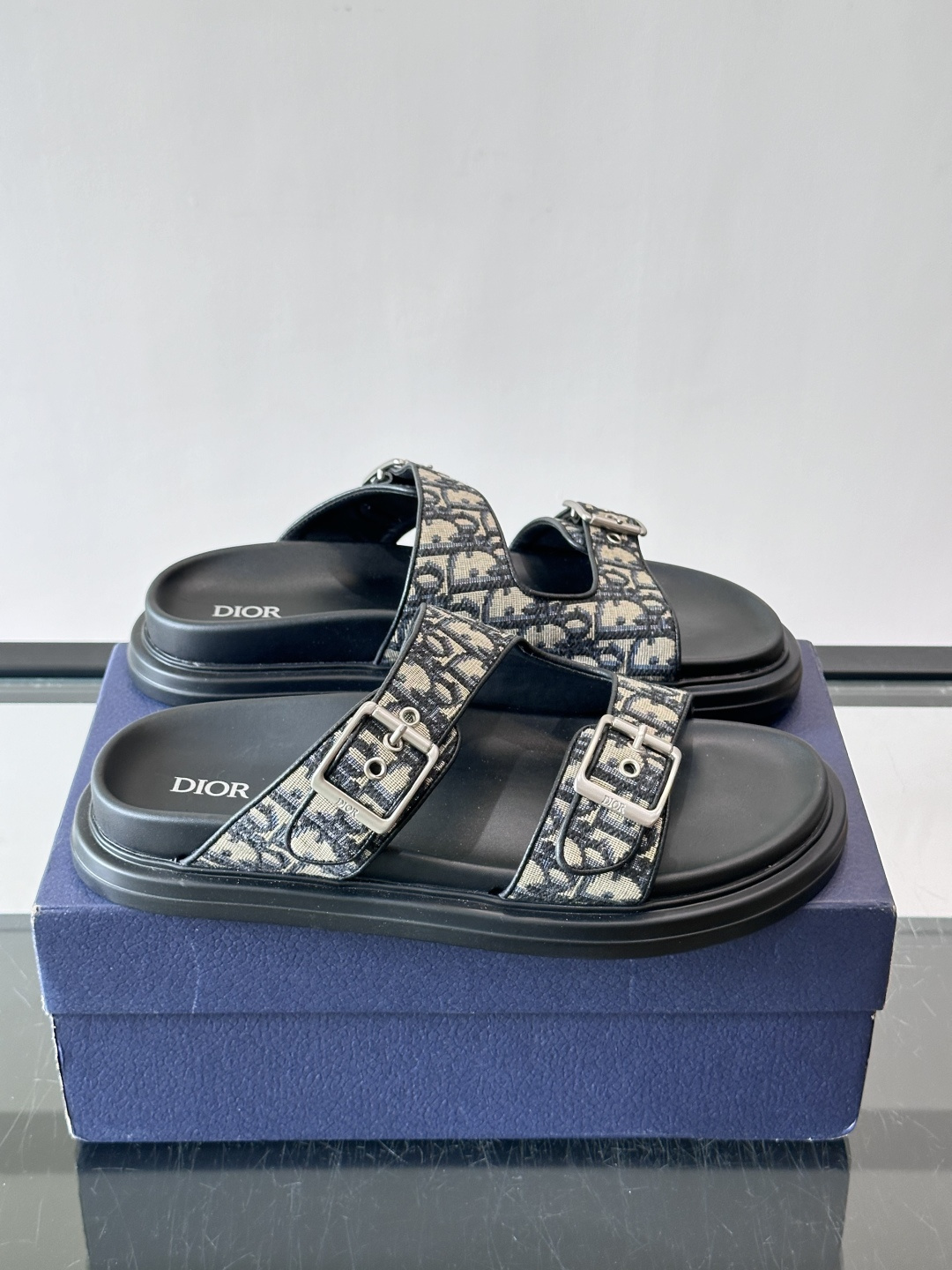 Dior Aqua 男士凉鞋拖鞋。展现 Dior 高订风格设计。迪奥灰绒面革饰带点缀以铝质 Dior 搭扣提升格调。搭配