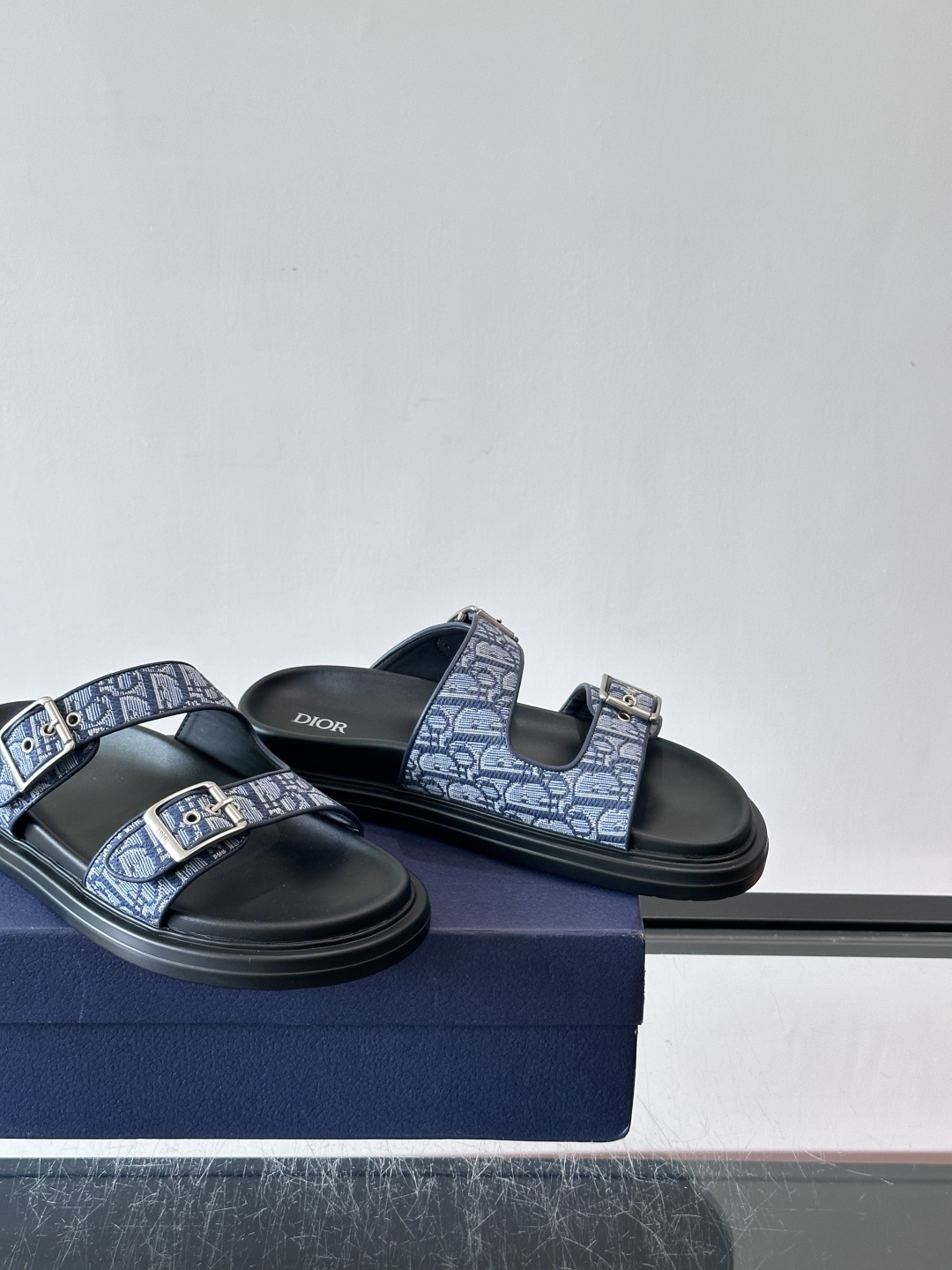 Dior Aqua 男士凉鞋拖鞋。展现 Dior 高订风格设计。迪奥灰绒面革饰带点缀以铝质 Dior 搭扣提升格调。搭配