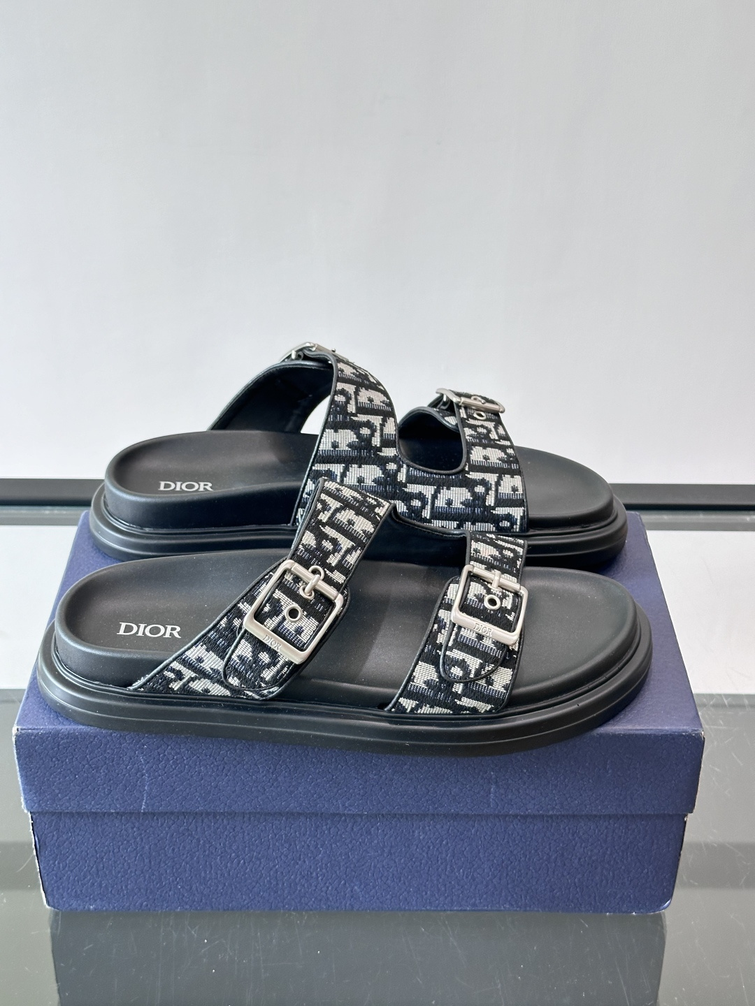 Dior Aqua 男士凉鞋拖鞋。展现 Dior 高订风格设计。迪奥灰绒面革饰带点缀以铝质 Dior 搭扣提升格调。搭配