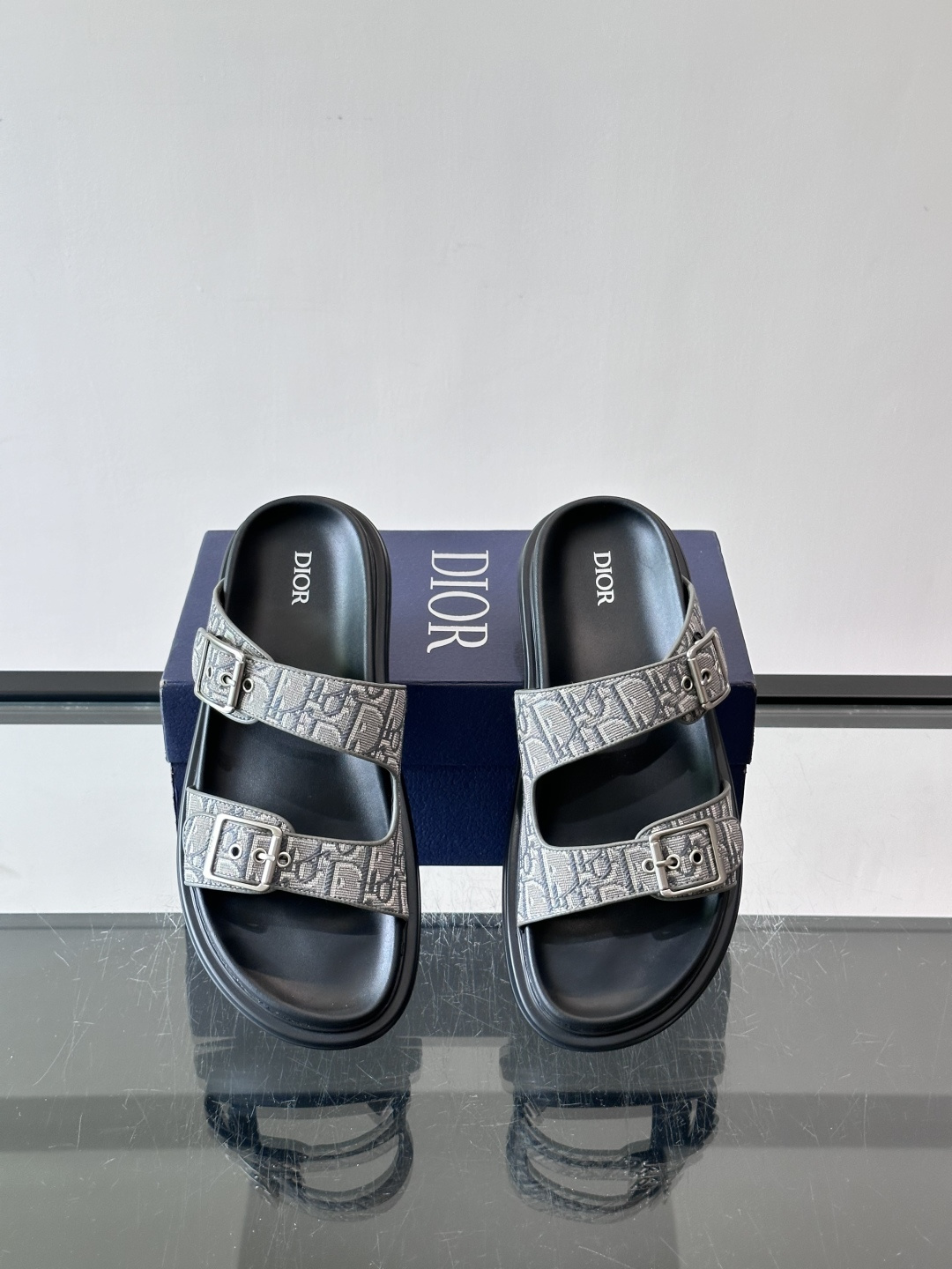 Dior Aqua 男士凉鞋拖鞋。展现 Dior 高订风格设计。迪奥灰绒面革饰带点缀以铝质 Dior 搭扣提升格调。搭配 Dior Aqua 男士凉鞋拖鞋。展现 Dior 高订风格设计。迪奥灰绒面革饰带点缀以铝质 Dior 搭扣提升格调。搭配