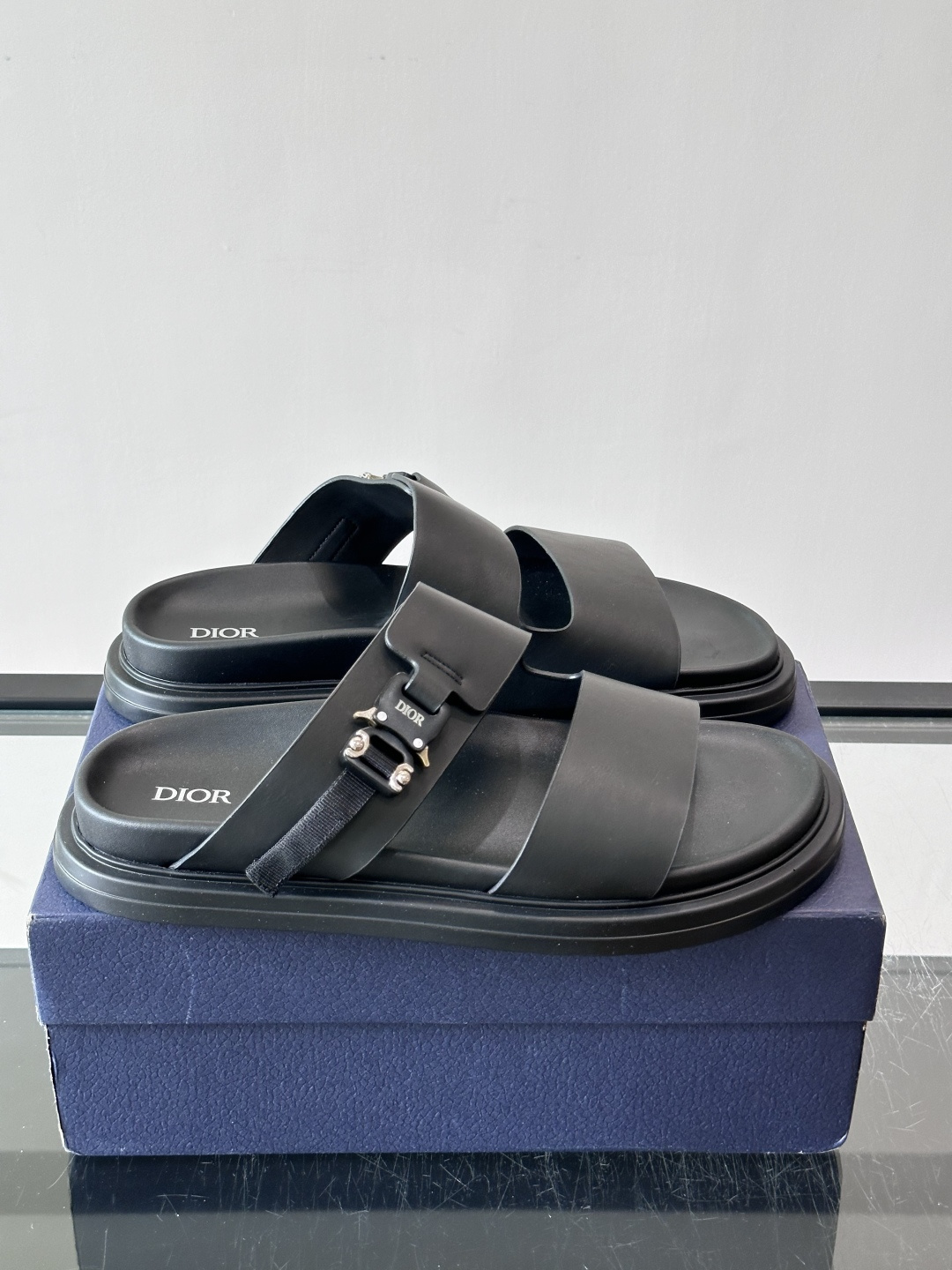 Dior Aqua 男士凉鞋拖鞋。展现 Dior 高订风格设计。迪奥灰绒面革饰带点缀以铝质 Dior 搭扣提升格调。搭配