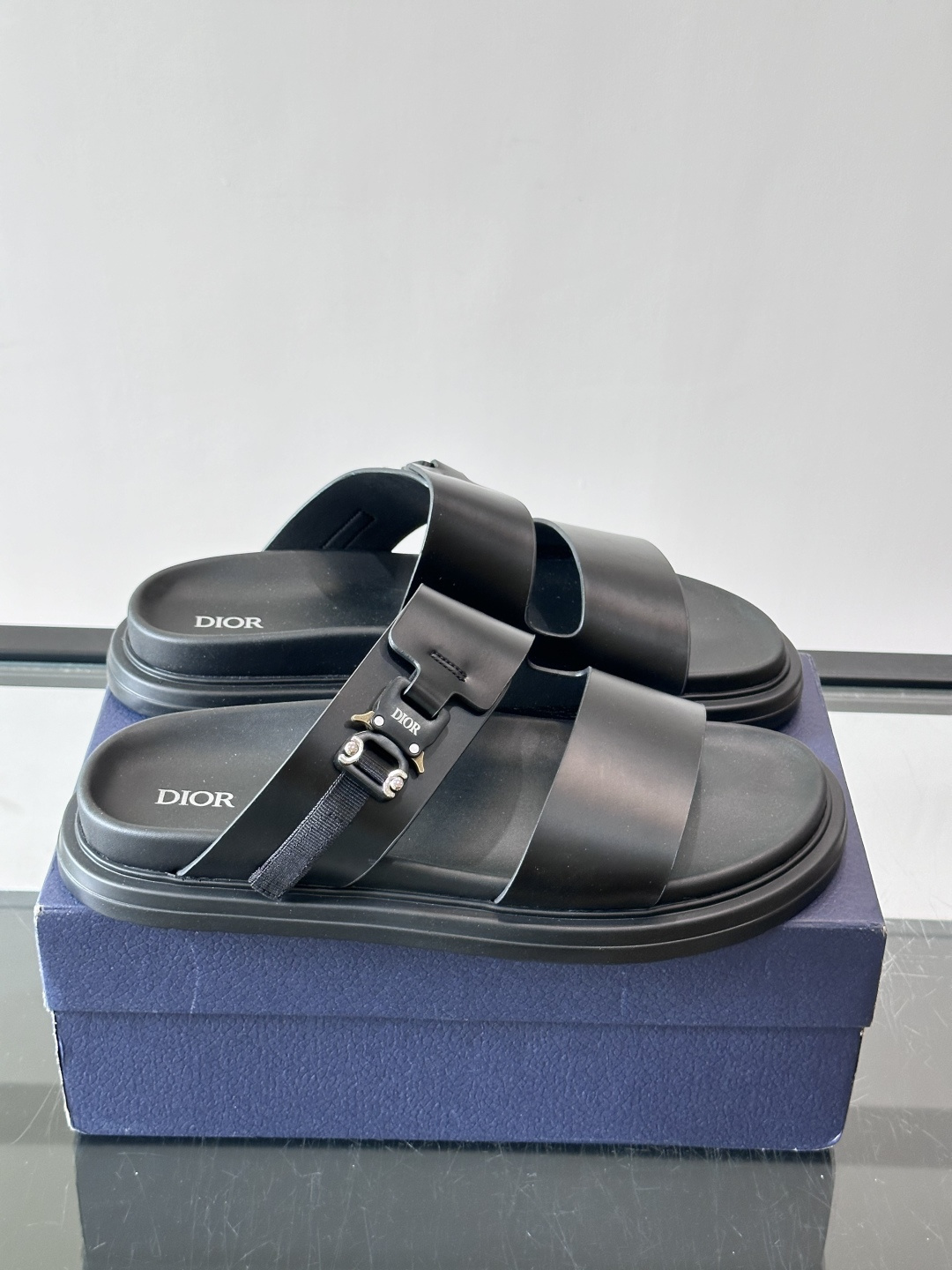 Dior Aqua 男士凉鞋拖鞋。展现 Dior 高订风格设计。迪奥灰绒面革饰带点缀以铝质 Dior 搭扣提升格调。搭配