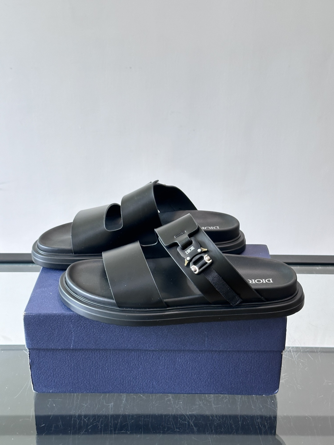 Dior Aqua 男士凉鞋拖鞋。展现 Dior 高订风格设计。迪奥灰绒面革饰带点缀以铝质 Dior 搭扣提升格调。搭配