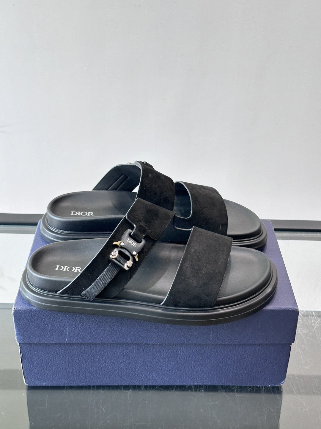 Dior Aqua 男士凉鞋拖鞋。展现 Dior 高订风格设计。迪奥灰绒面革饰带点缀以铝质 Dior 搭扣提升格调。搭配