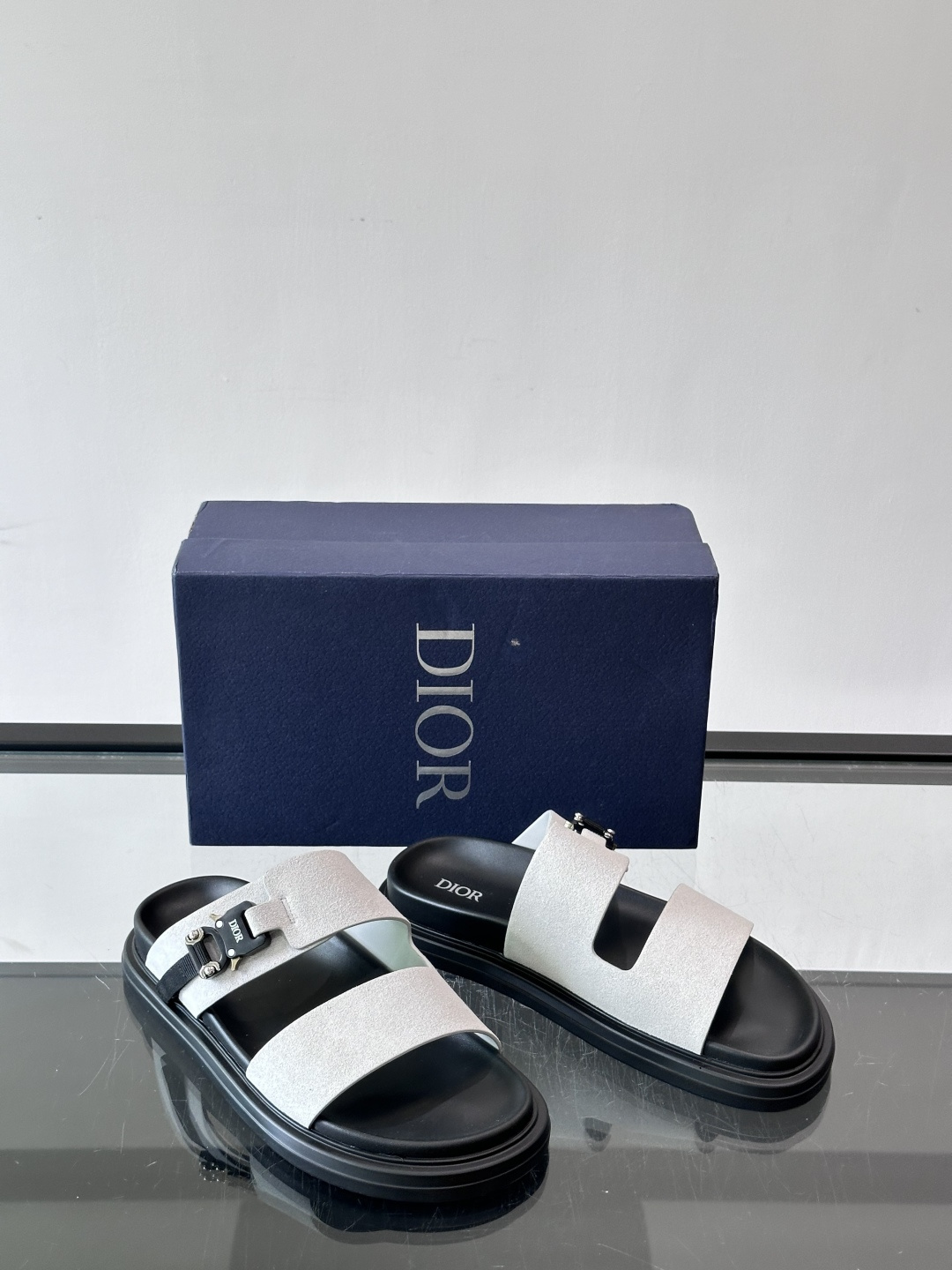 Dior Aqua 男士凉鞋拖鞋。展现 Dior 高订风格设计。迪奥灰绒面革饰带点缀以铝质 Dior 搭扣提升格调。搭配