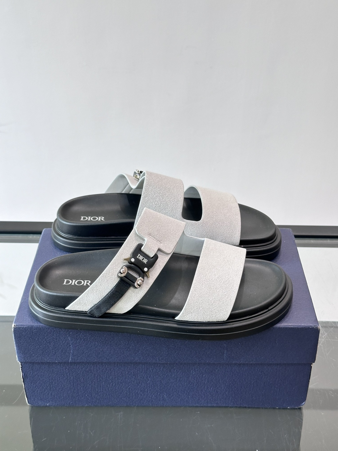 Dior Aqua 男士凉鞋拖鞋。展现 Dior 高订风格设计。迪奥灰绒面革饰带点缀以铝质 Dior 搭扣提升格调。搭配