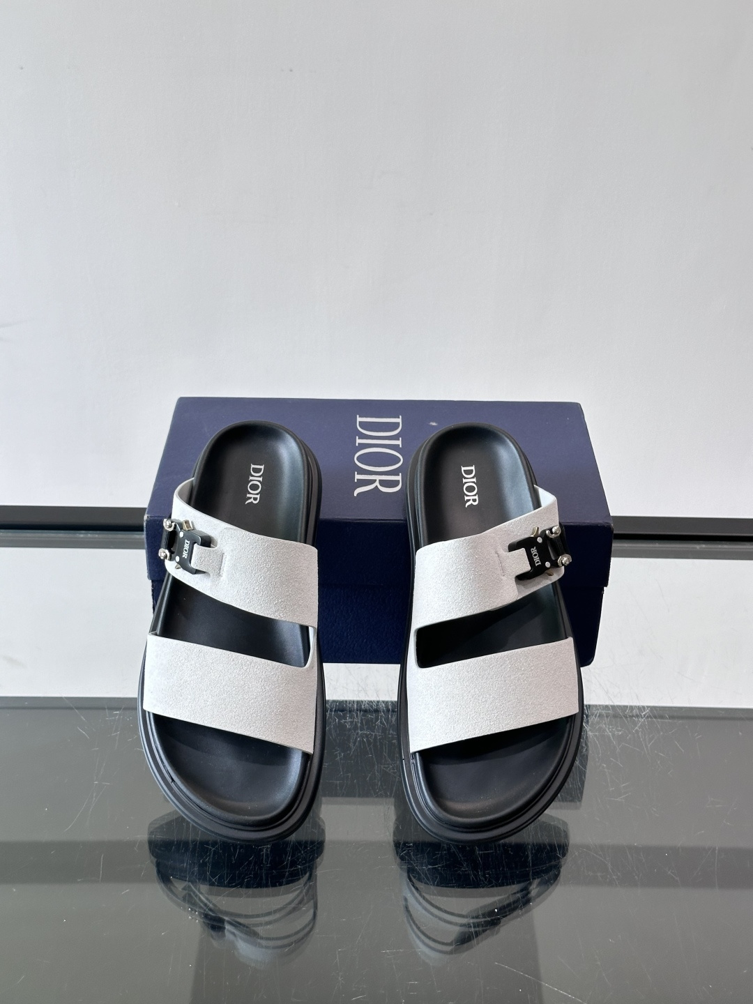 Dior Aqua 男士凉鞋拖鞋。展现 Dior 高订风格设计。迪奥灰绒面革饰带点缀以铝质 Dior 搭扣提升格调。搭配