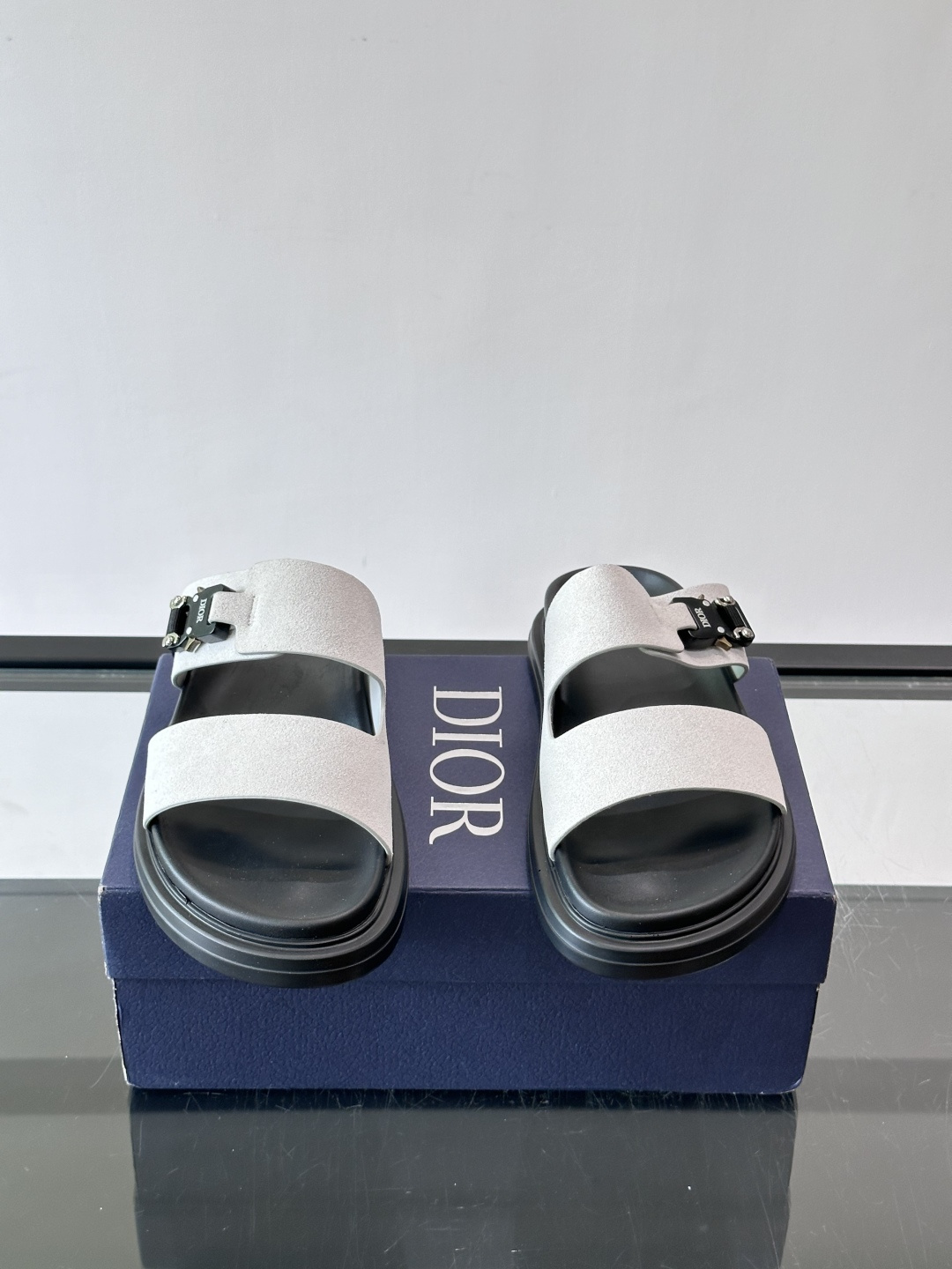 Dior Aqua 男士凉鞋拖鞋。展现 Dior 高订风格设计。迪奥灰绒面革饰带点缀以铝质 Dior 搭扣提升格调。搭配